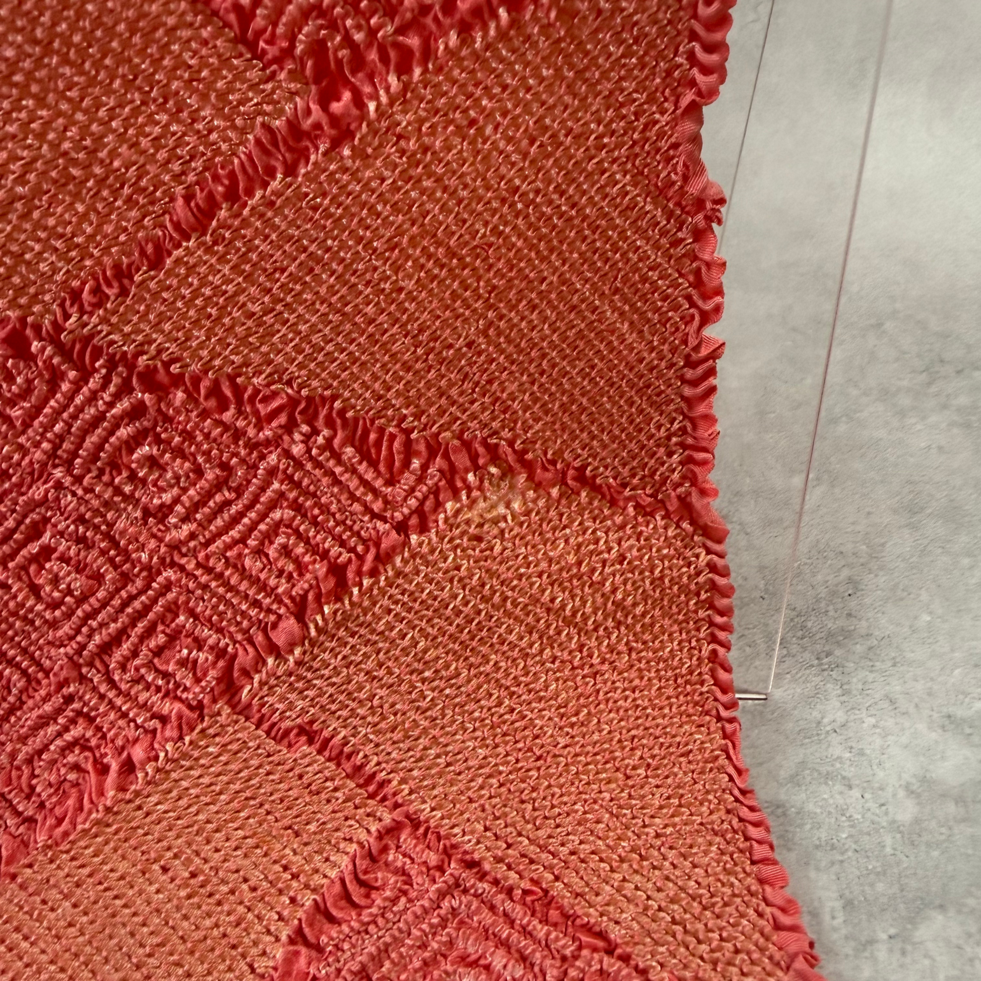 Detailed view of yellow-brown age-related discolouration on coral pink shibori obiage