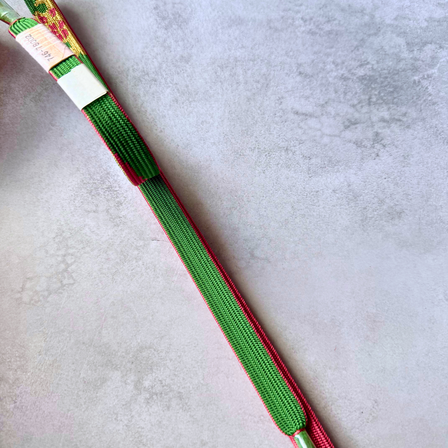 Close-up of the deep green reverse side and fine braiding of a Japanese silk kumihimo obijime