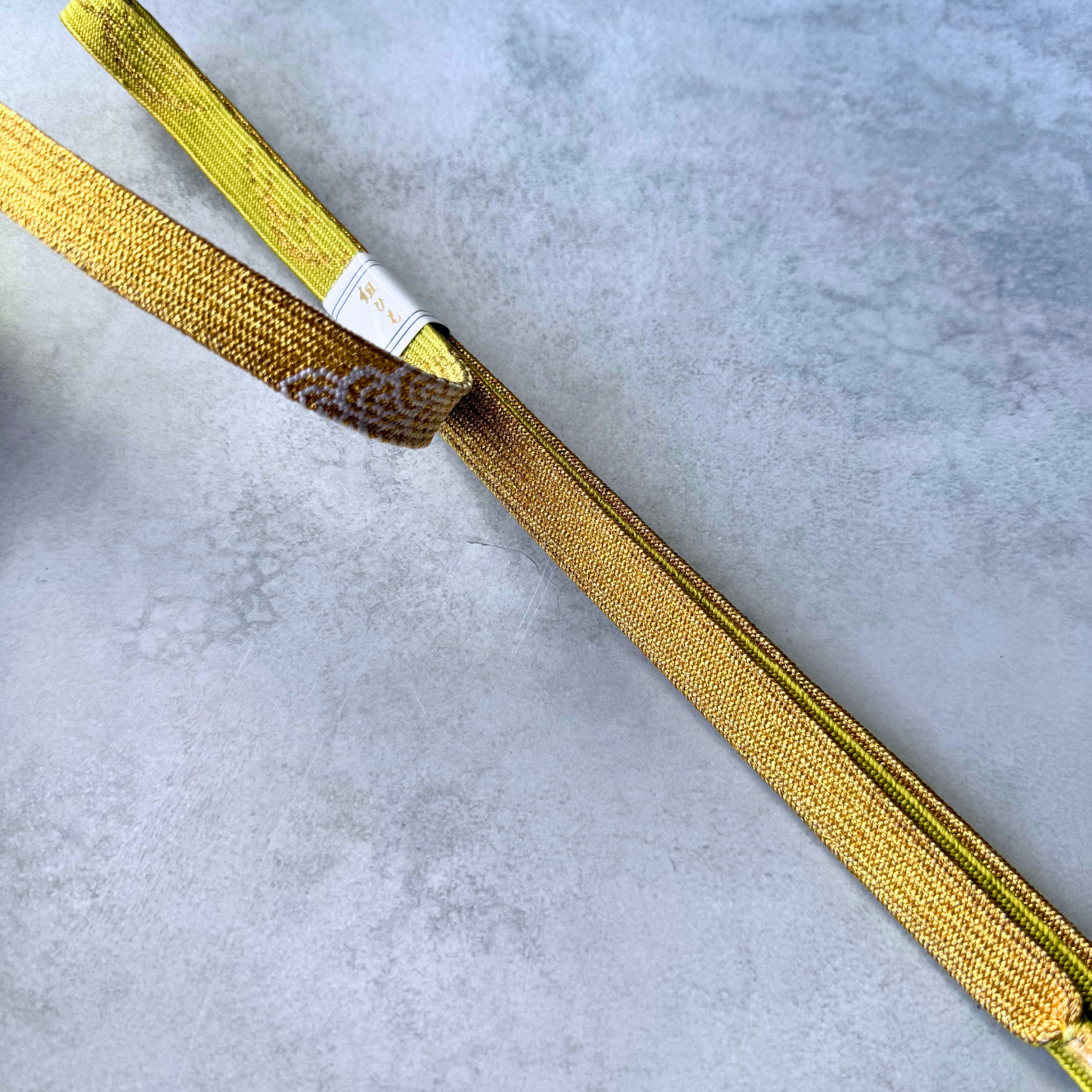 Close-up comparison of the golden brown and olive sides with fine kumihimo braiding