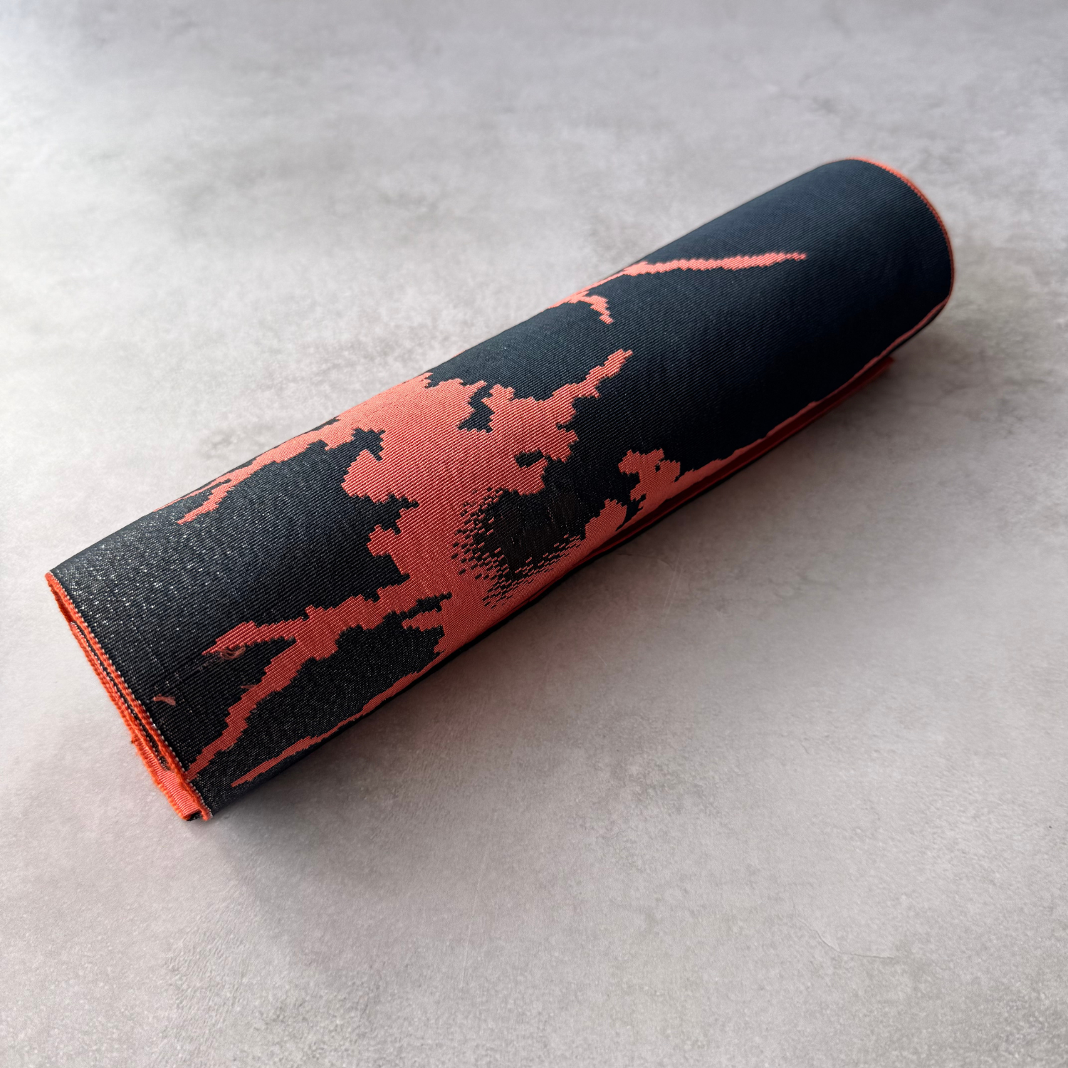 Rolled black and coral Japanese hachisun obi fabric for crafts