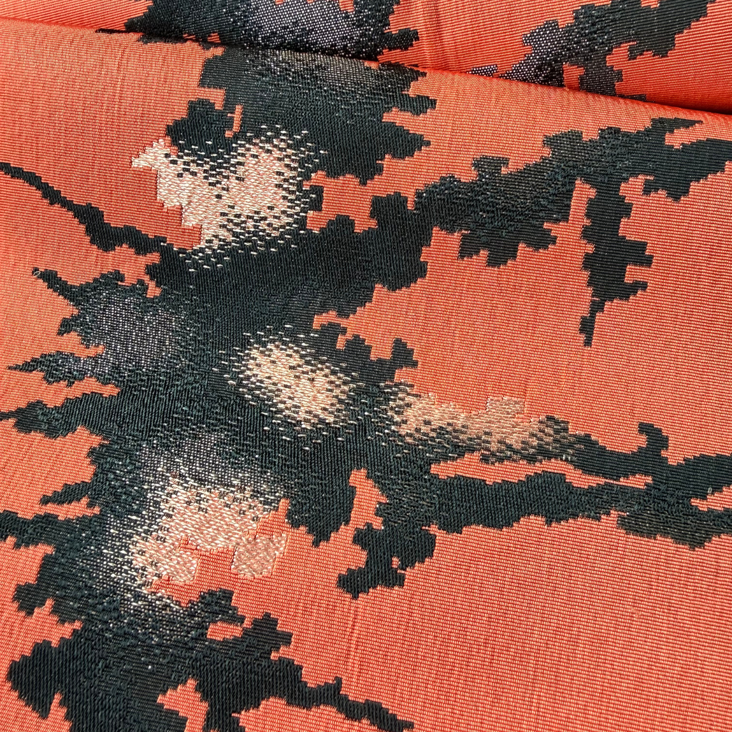 Detailed woven abstract pattern on coral pink Japanese obi textile
