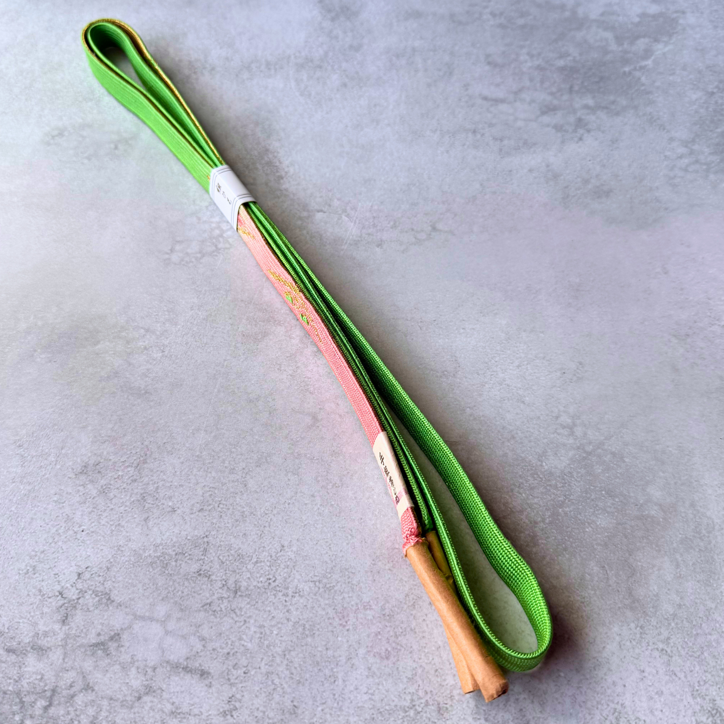 Front and reverse sides of spring green and blush pink silk obijime with tassel ends