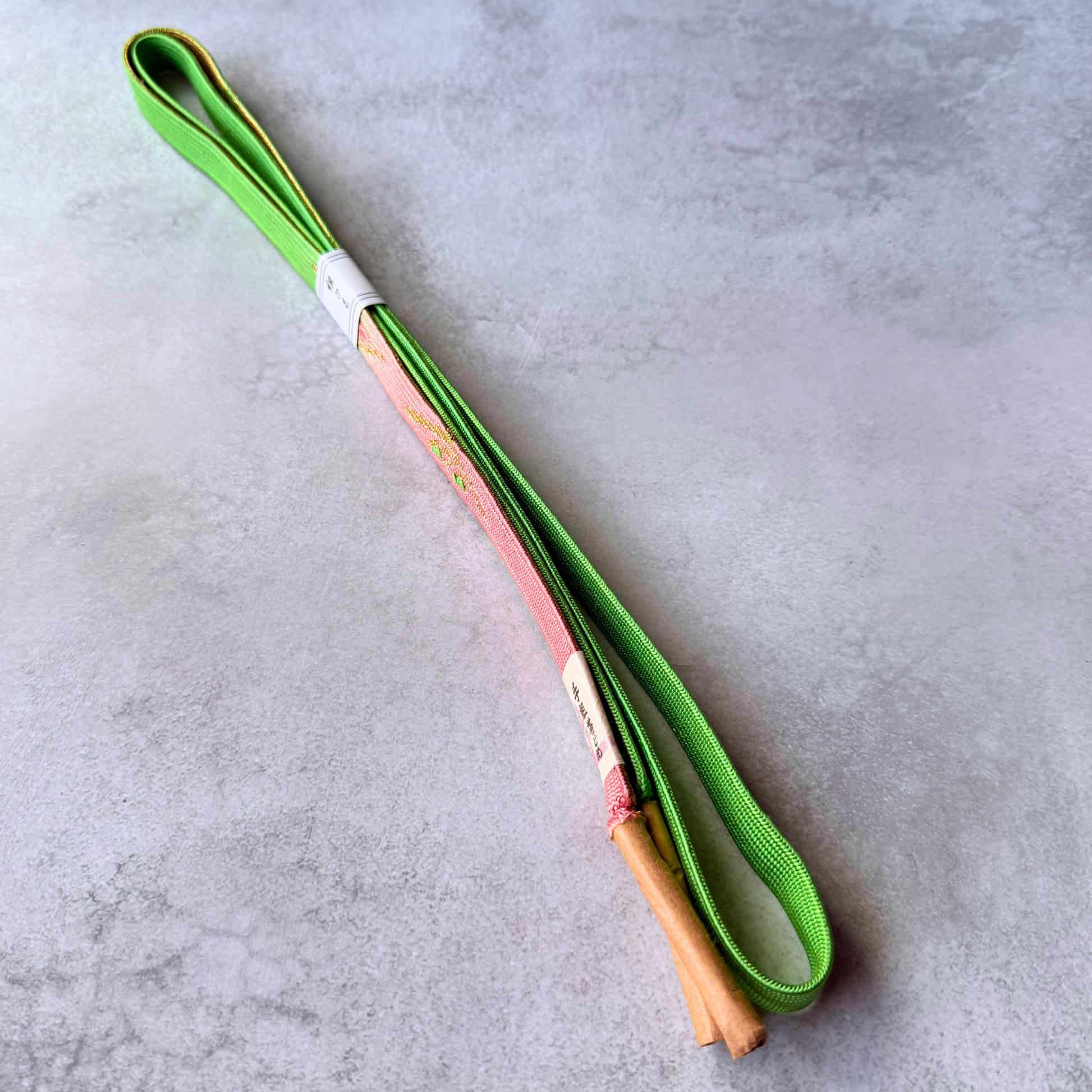 Front and reverse sides of spring green and blush pink silk obijime with tassel ends