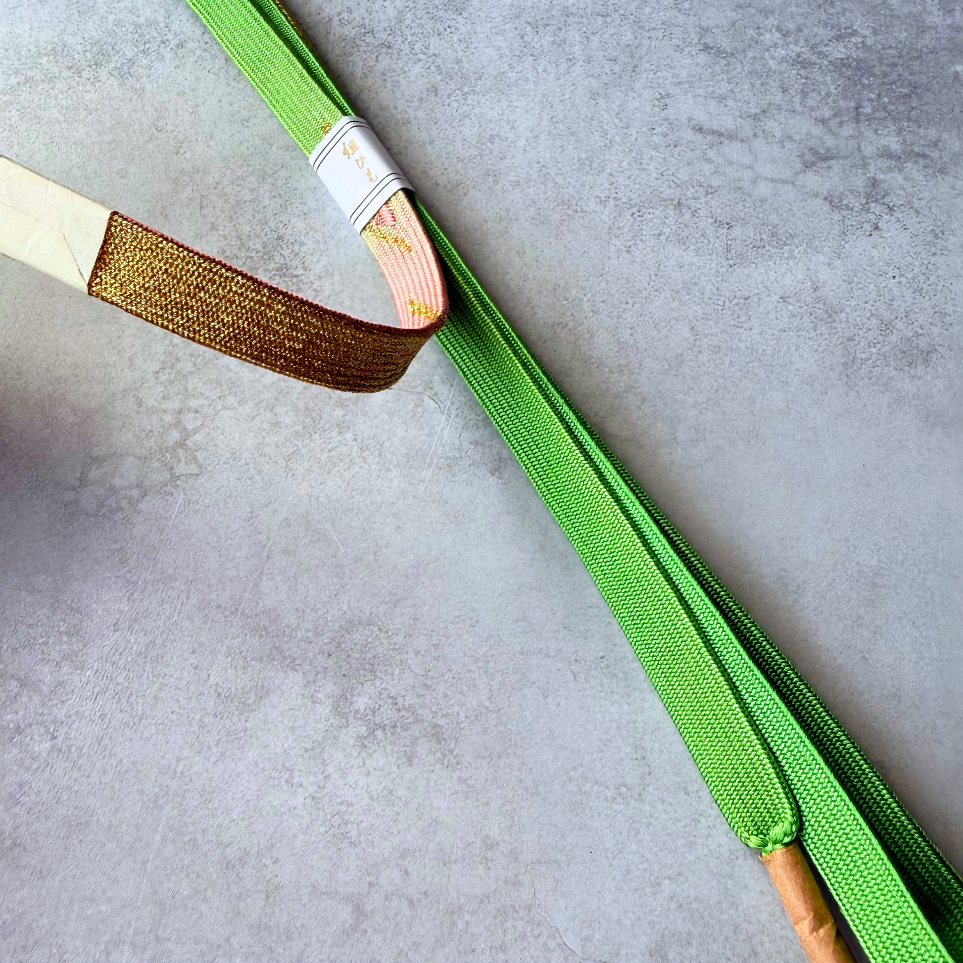 Close-up comparison of golden brown reverse, blush pink motif section and spring green silk weave