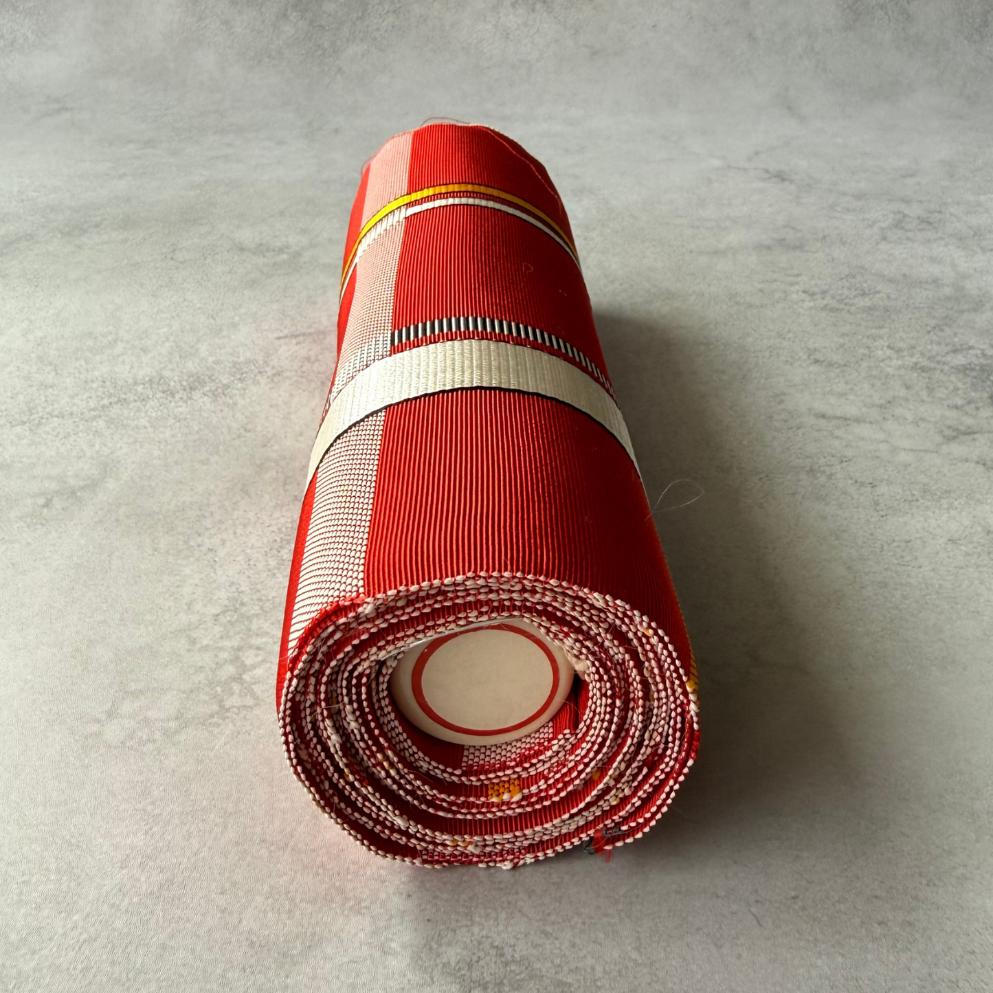 End view of rolled pre-owned Japanese obi fabric bolt
