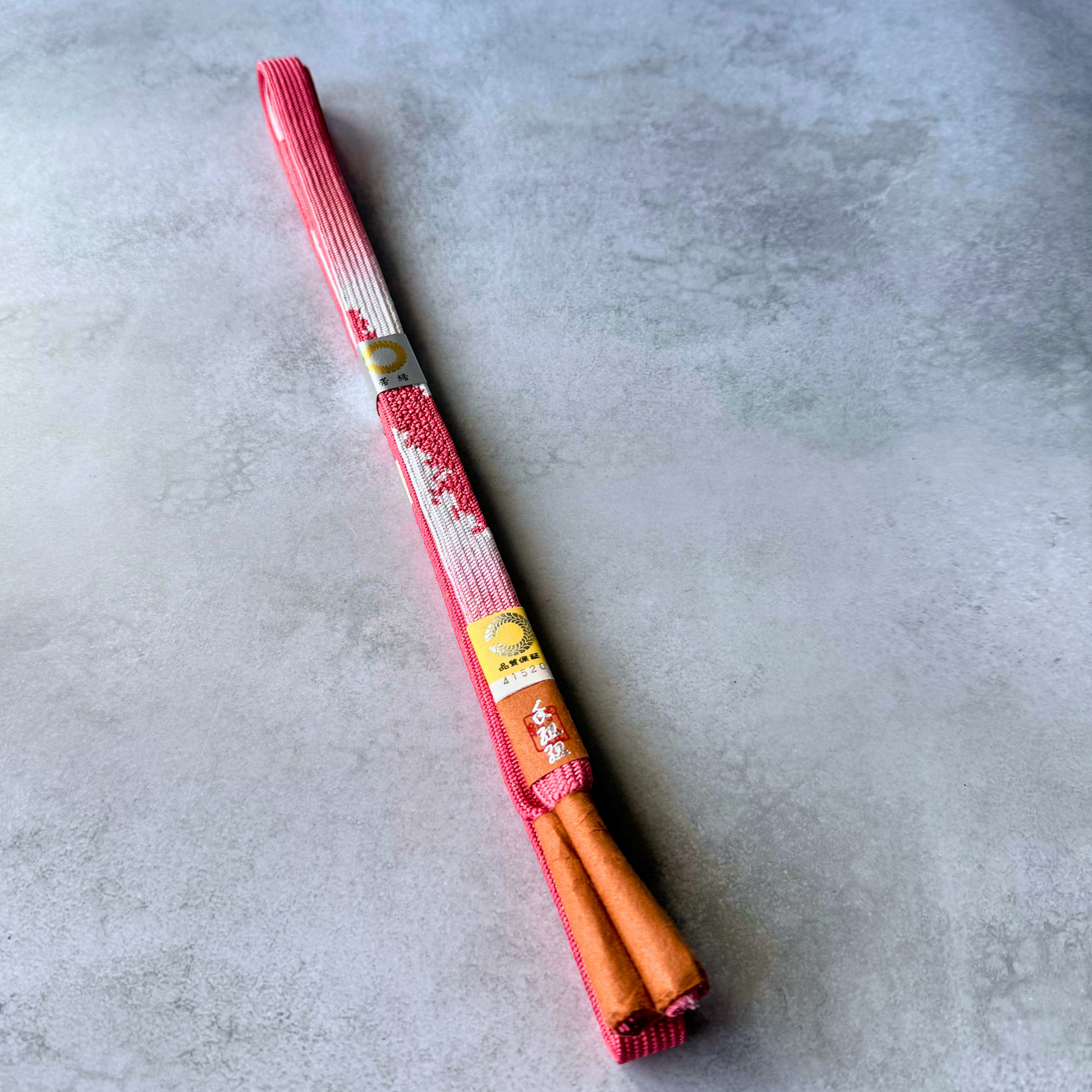 Unused Japanese hand-braided silk Korai-gumi obijime in coral pink, white and red, folded full view