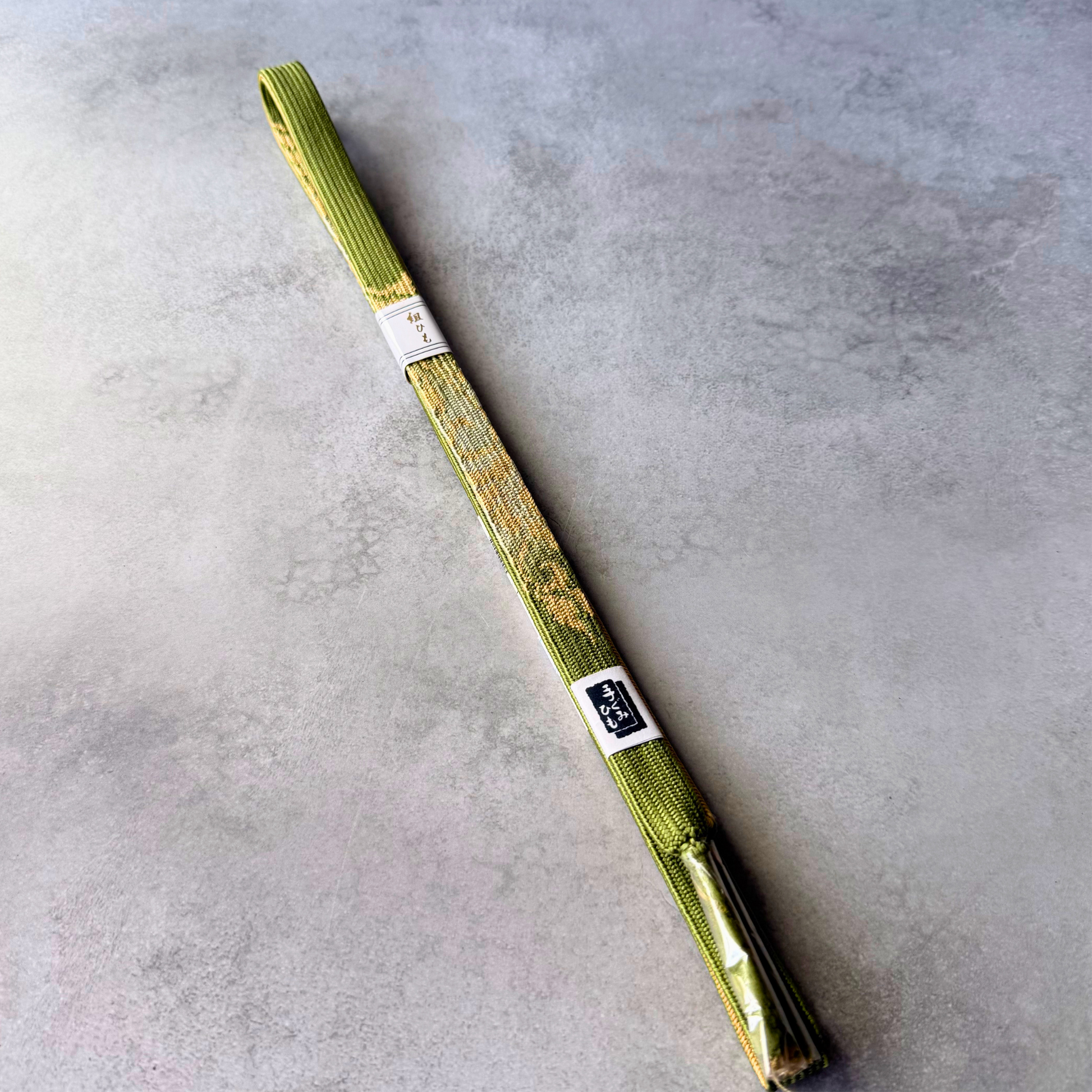 Unused Japanese silk Korai-gumi obijime cord in olive green and gold, full view