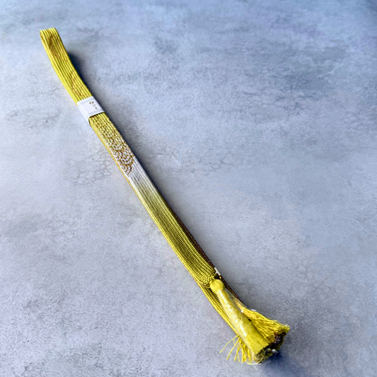 Full view of an unused Japanese silk Korai-gumi obijime in olive yellow, white and gold