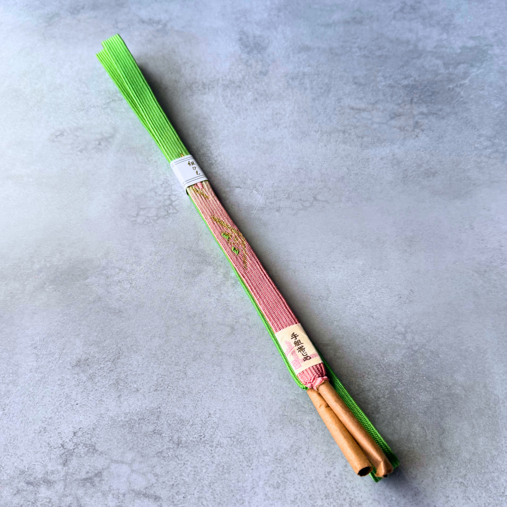 Japanese hand-braided silk Korai-gumi obijime in vivid spring green and blush pink, full view