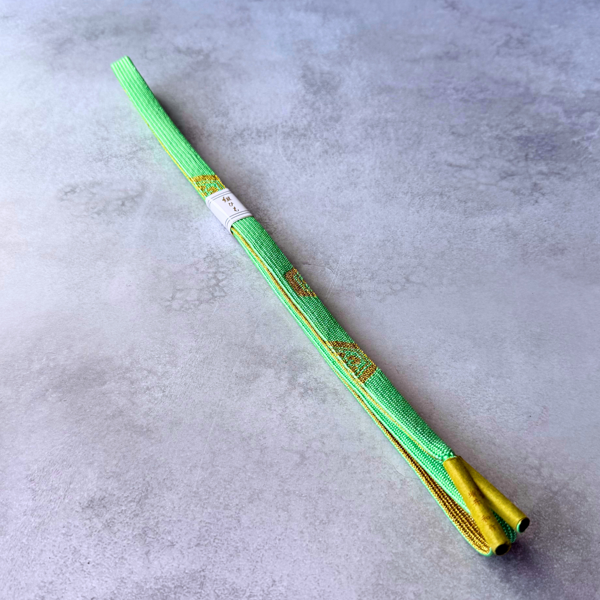 Unused Japanese hand-braided silk Korai-gumi obijime in bright spring green and metallic gold, full view