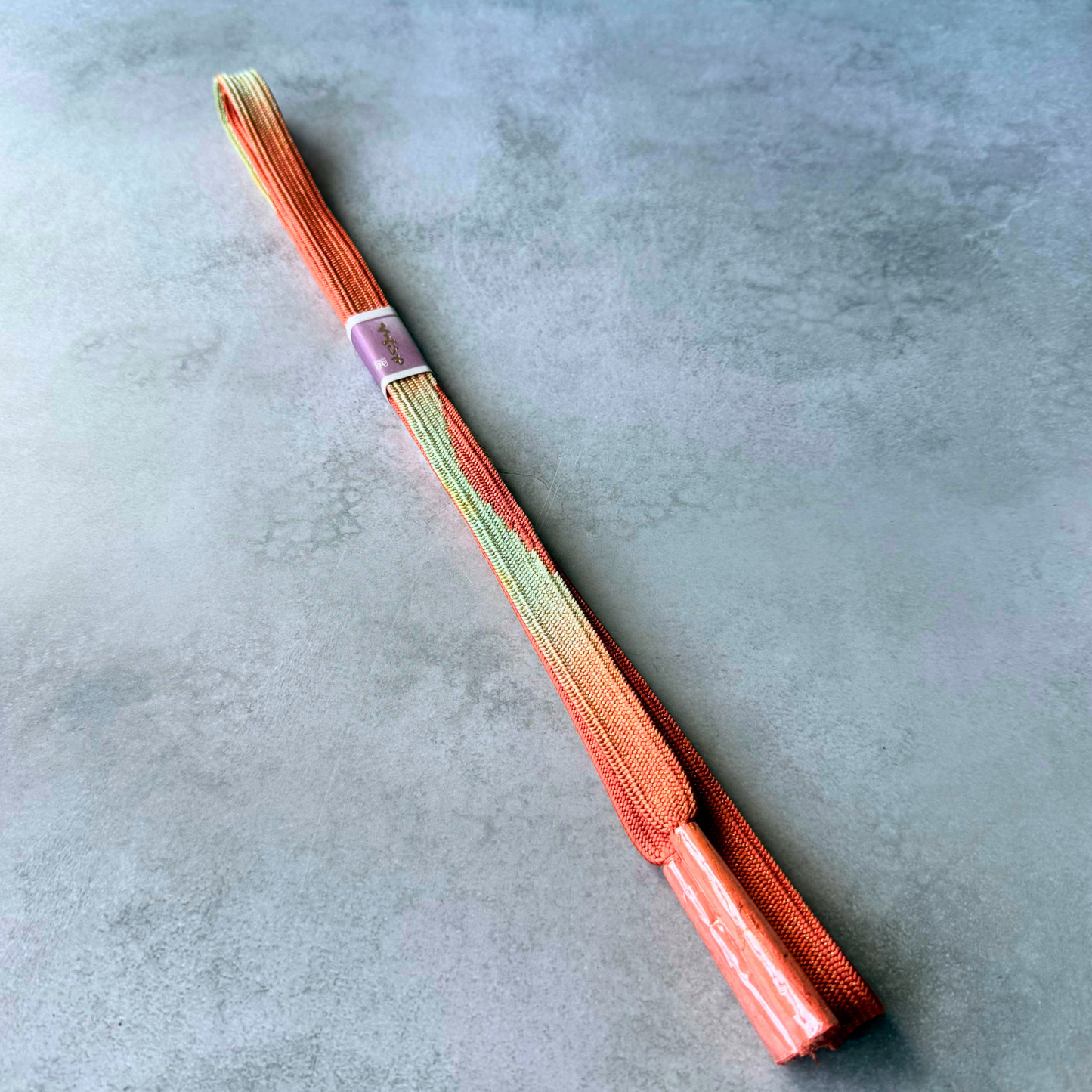 Full view of unused Japanese silk Korai-gumi obijime cord in vermilion red, pale green and gold