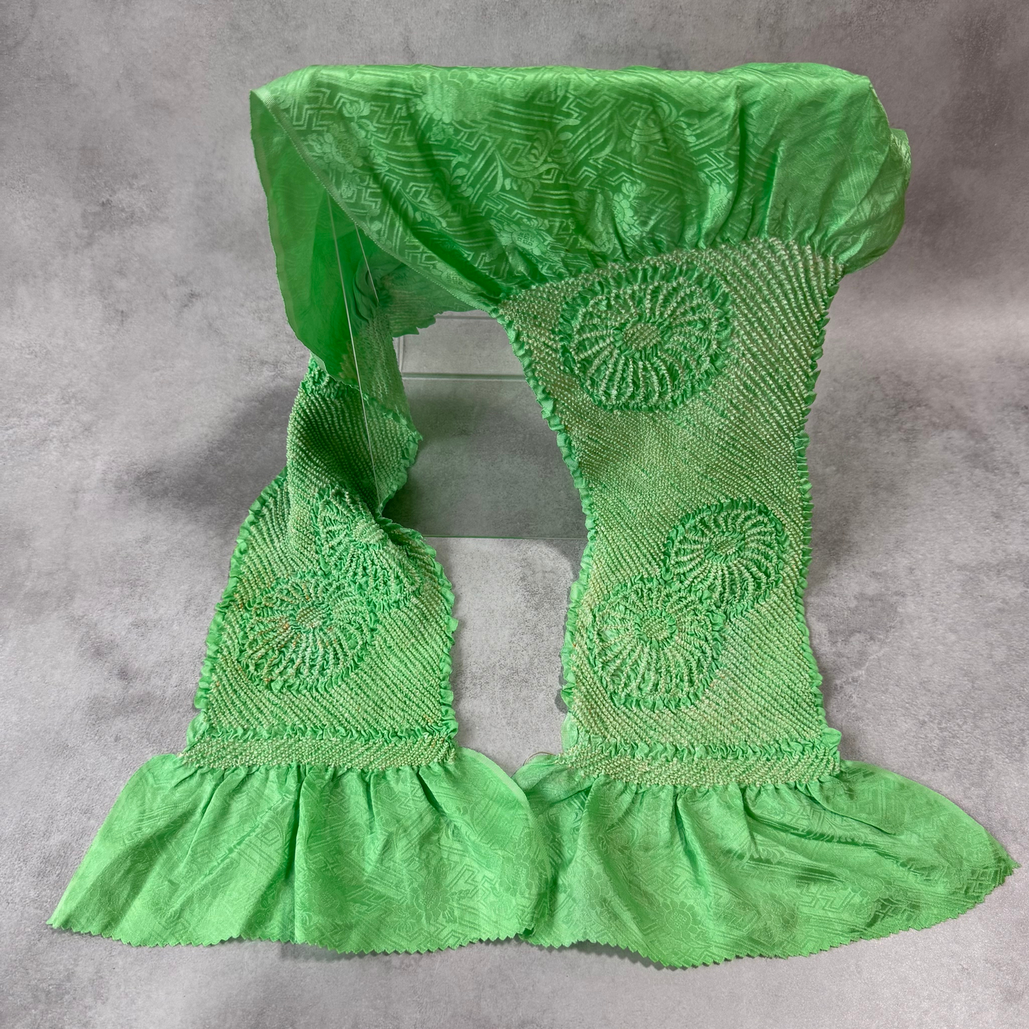 Full view of a vintage Japanese silk shibori obiage in bright green with large floral motifs