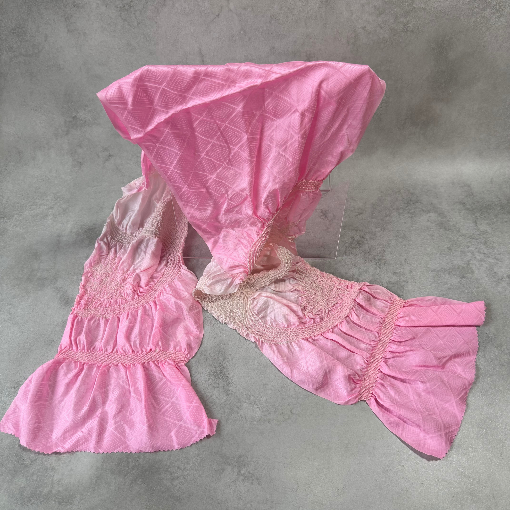 Full view of a vintage Japanese silk shibori obiage in pink ombre with geometric woven pattern