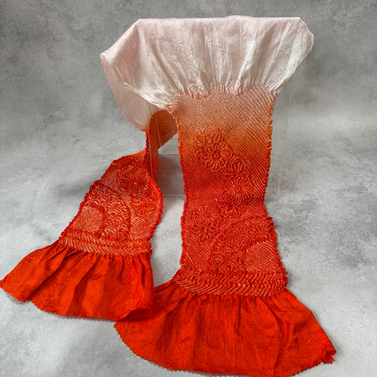 Full view of a vintage Japanese silk shibori obiage fading from vermilion orange to ivory