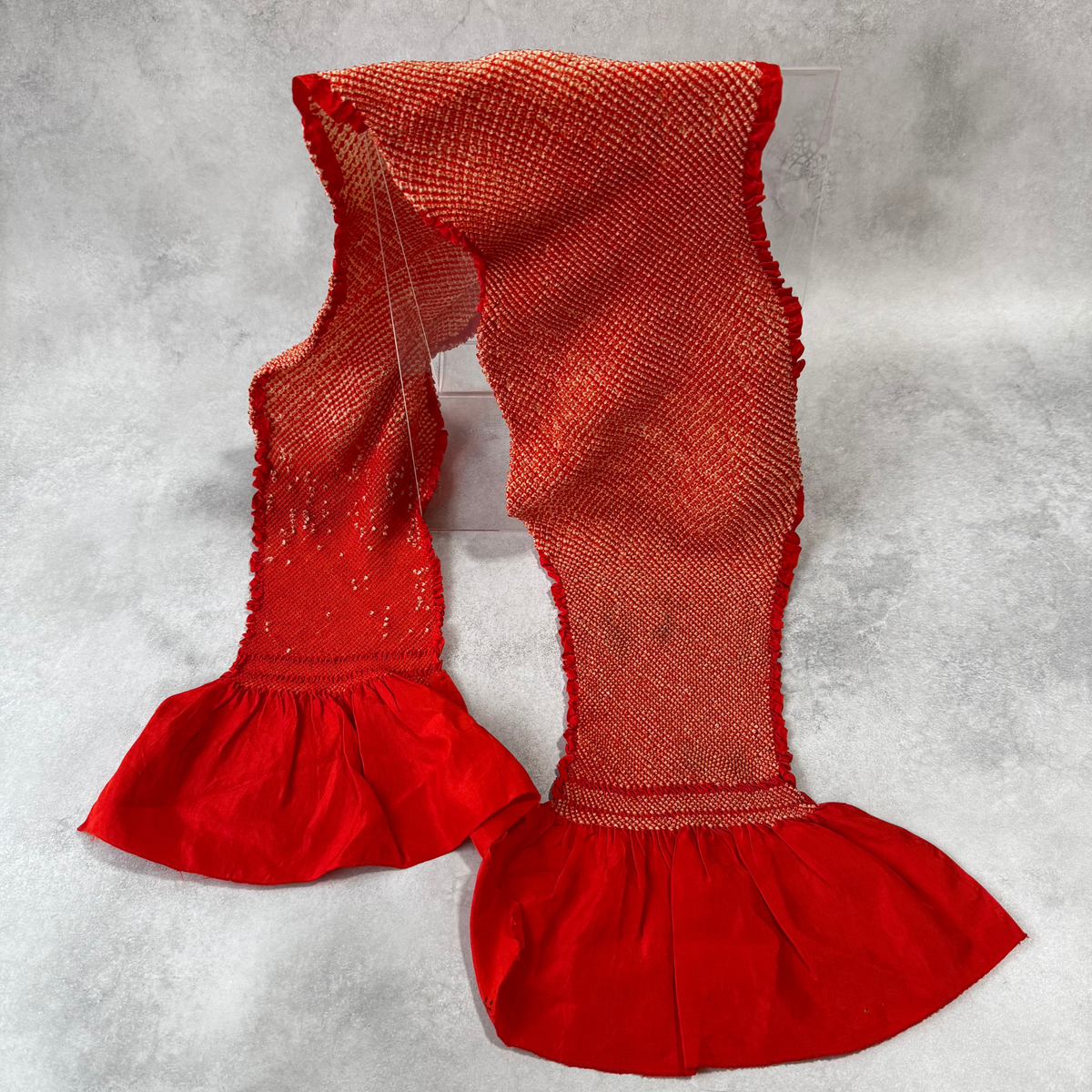 Full view of a vintage Japanese silk shibori obiage in vermilion red and ivory
