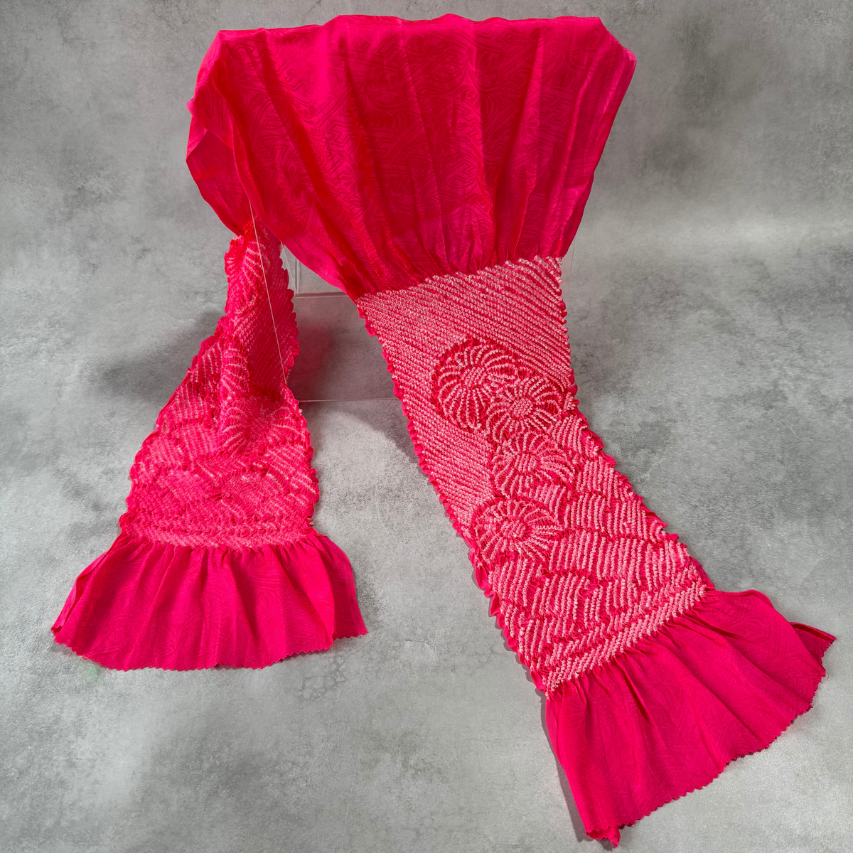Full view of a vintage Japanese silk shibori obiage in vivid magenta pink with white floral motifs