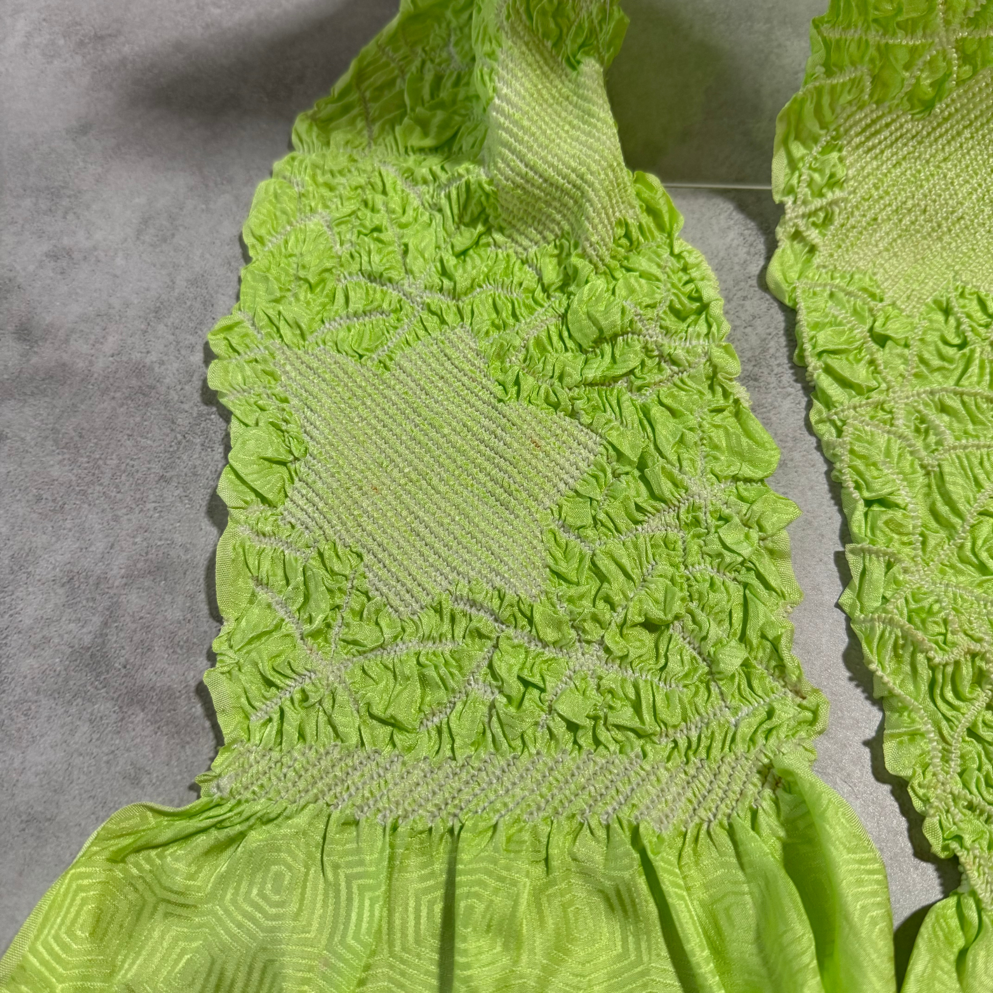 Close-up showing a small brown spot on a pale shibori panel of lime green obiage