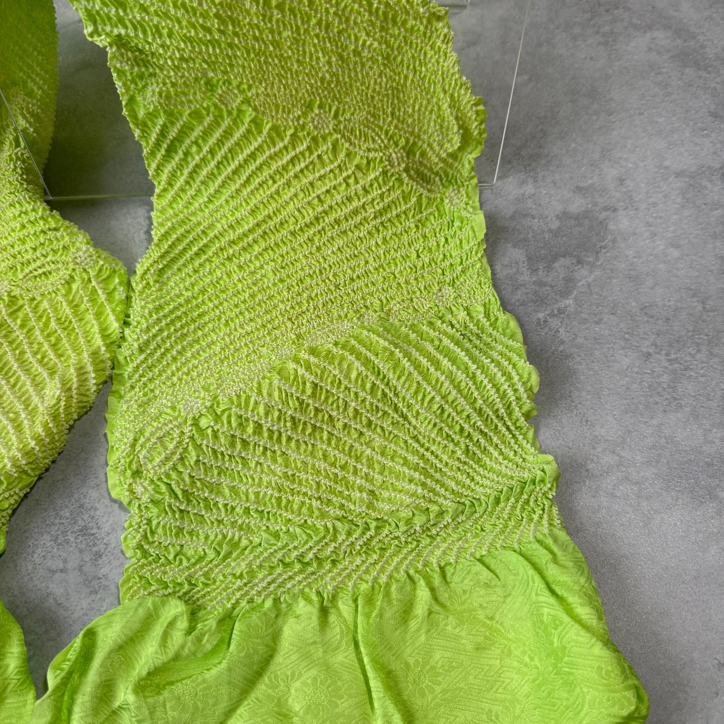 Close-up of large white floral shibori motifs on vivid lime green silk