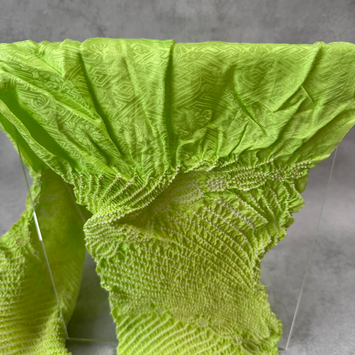Close-up of floral and geometric jacquard patterns woven into lime green silk