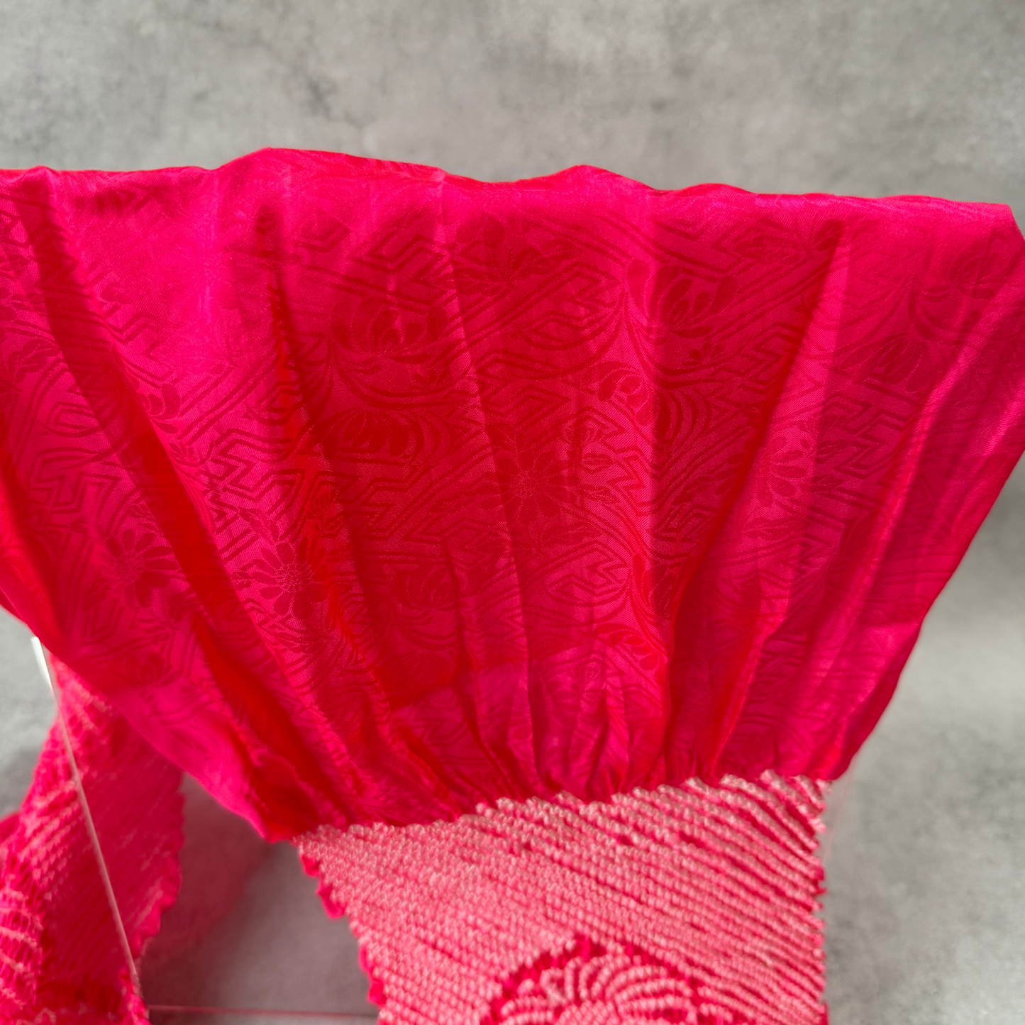 Close-up of floral and geometric jacquard patterns woven into magenta pink silk