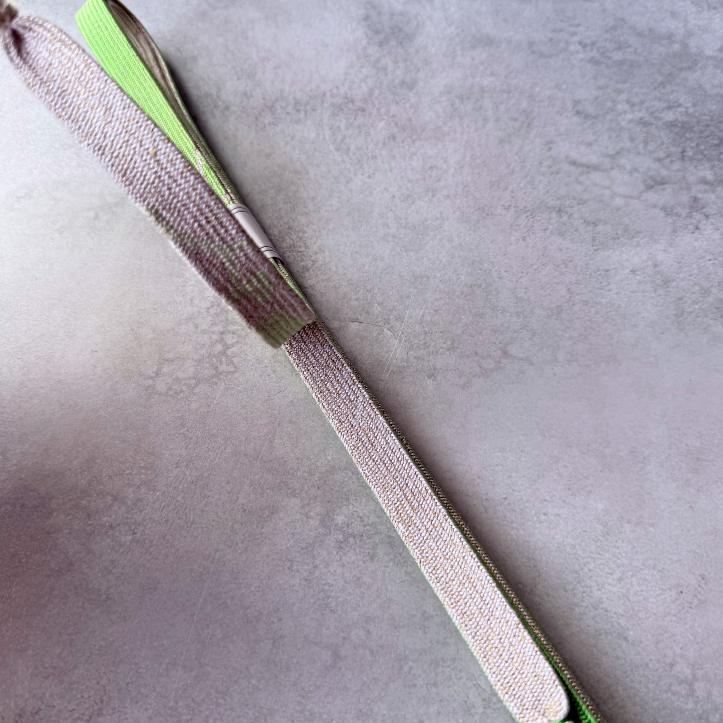 Close-up of the ivory and pale gold woven side and fine braid texture of the silk obijime