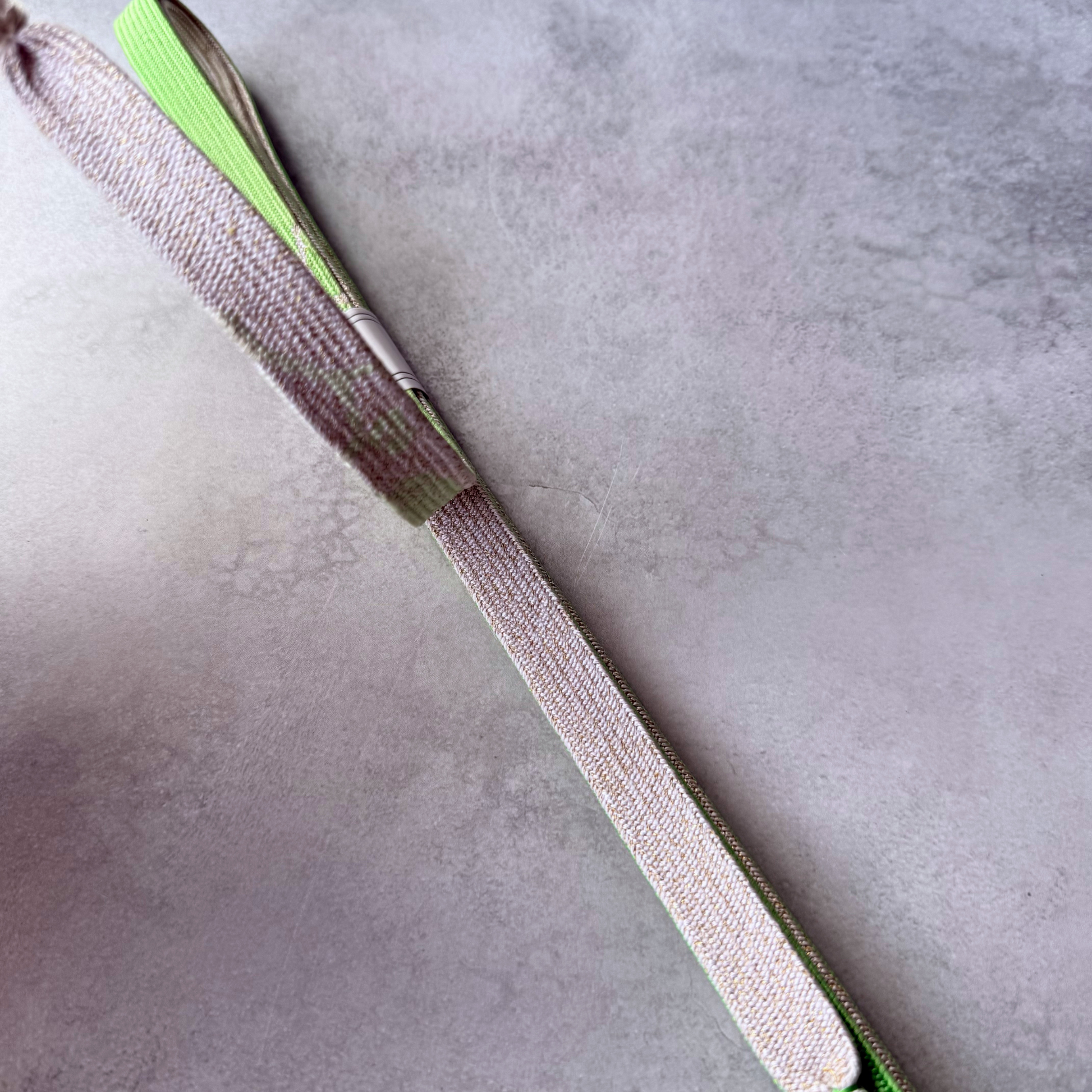 Close-up of the ivory and pale gold woven side and fine braid texture of the silk obijime