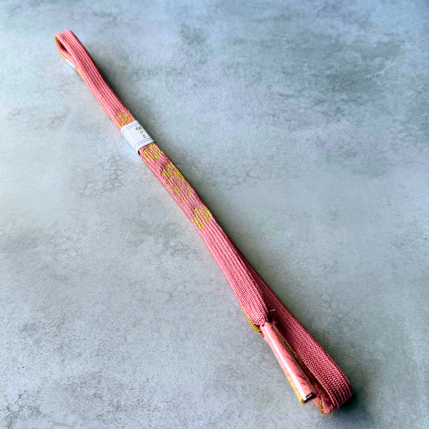 Full view of unused Japanese silk Korai-gumi obijime in dusty rose pink and metallic gold