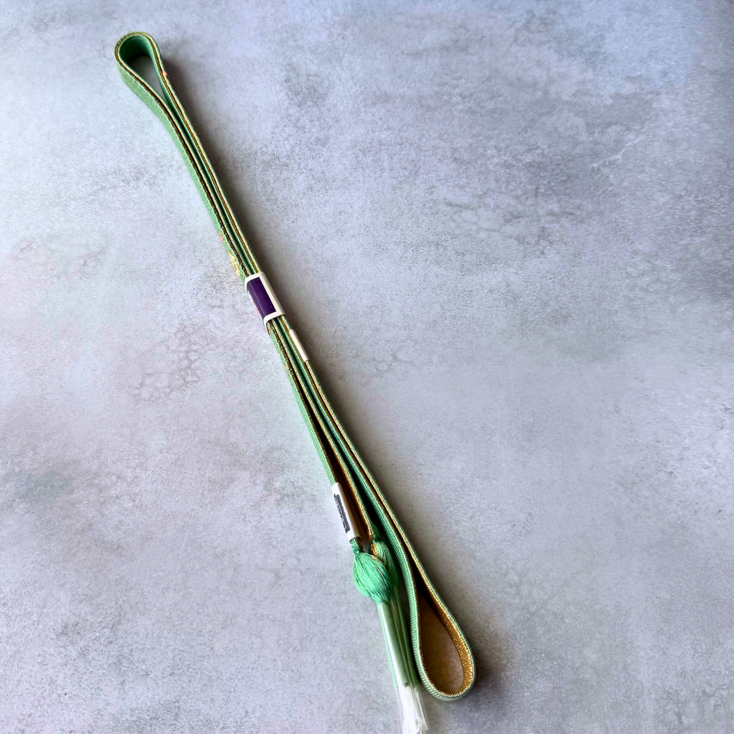 Front and reverse sides of celadon green and metallic gold silk obijime with tassels