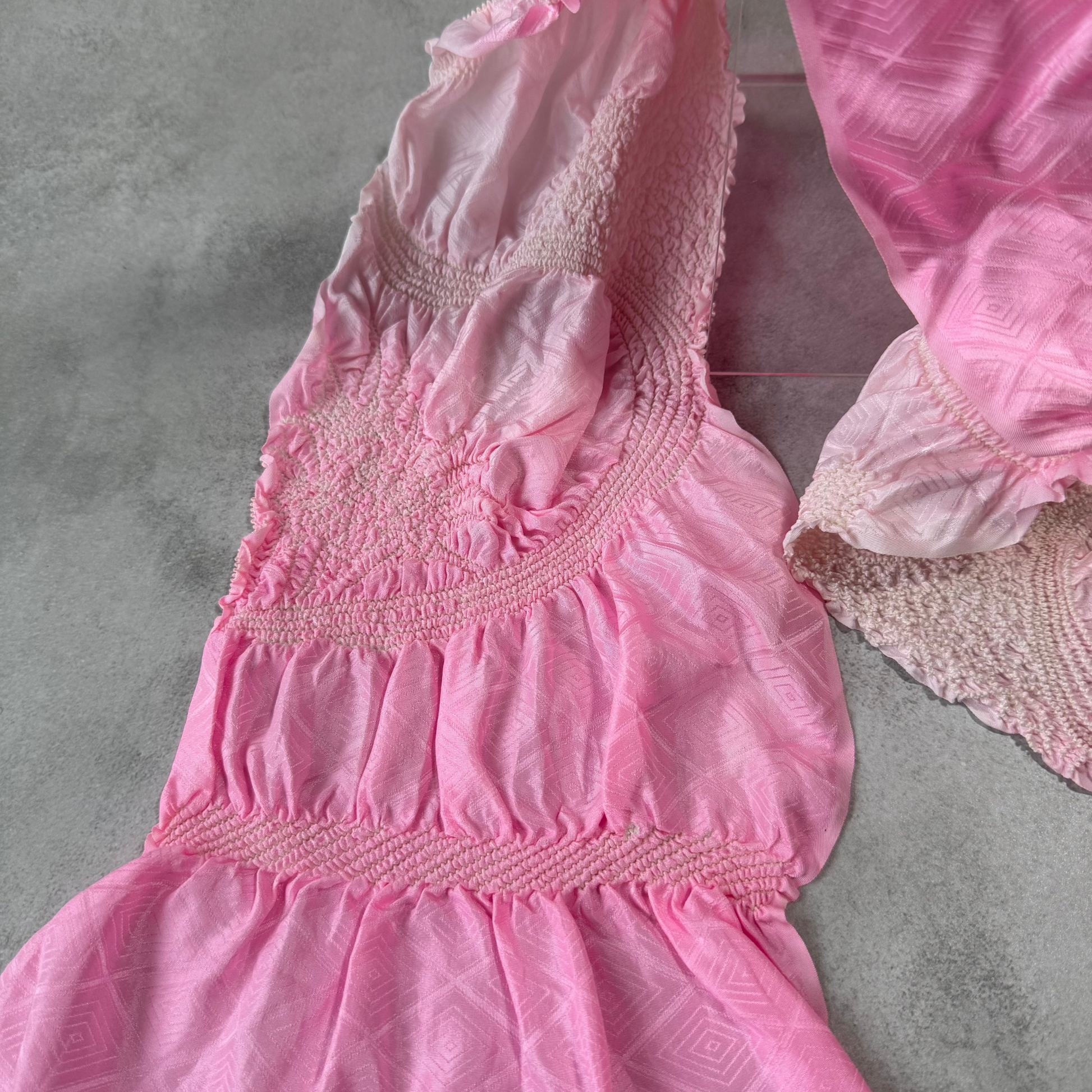 Close-up of pink tied-resist shibori sections on a Japanese silk obiage