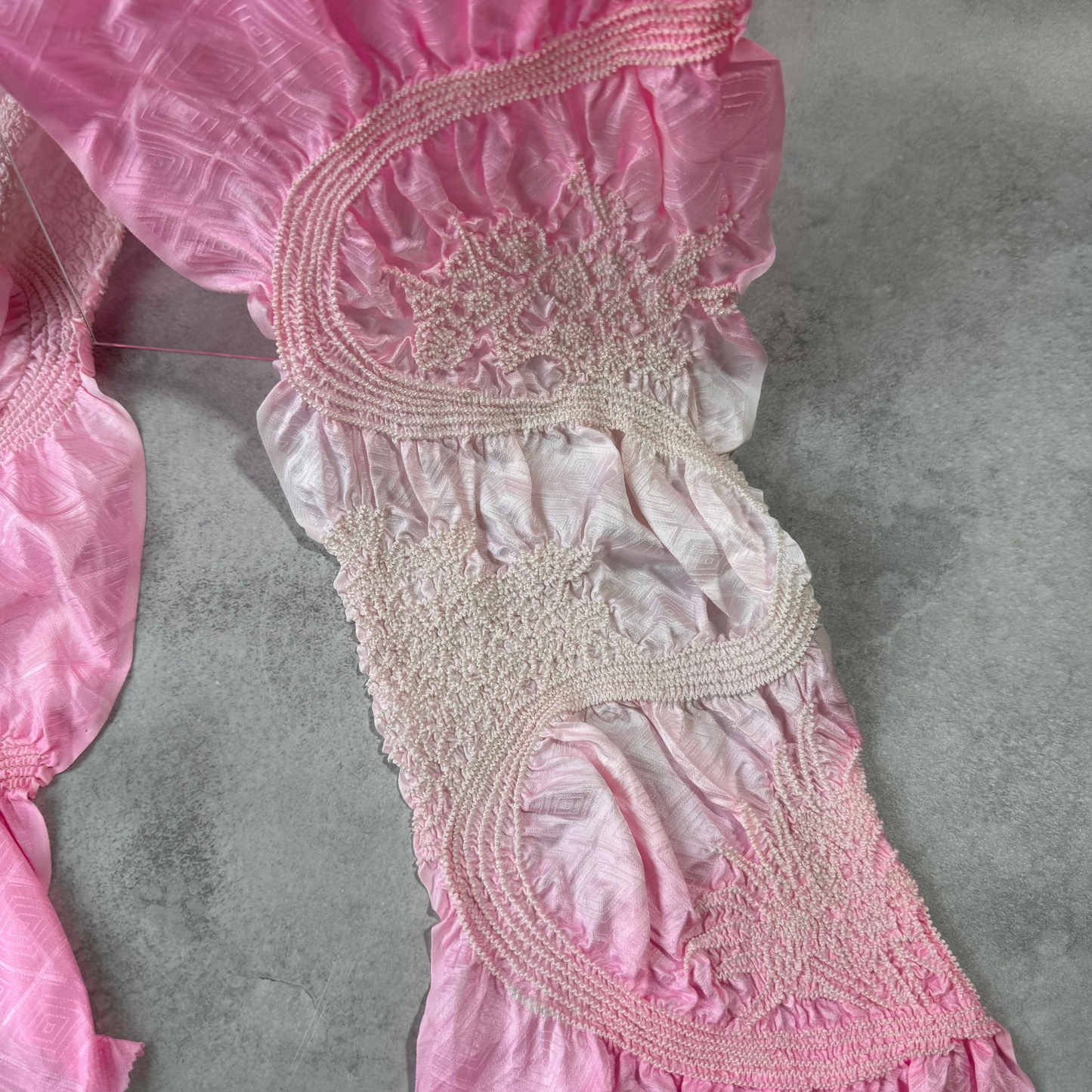 Close-up of the pale pink and white gradient shibori work on a Japanese silk obiage