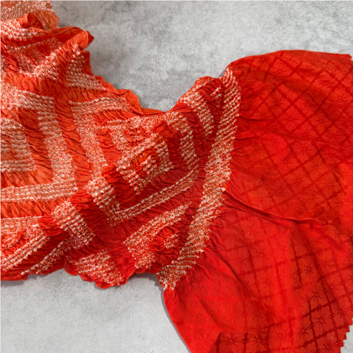 Japanese silk shibori obiage showing the red end and resist-dyed pattern