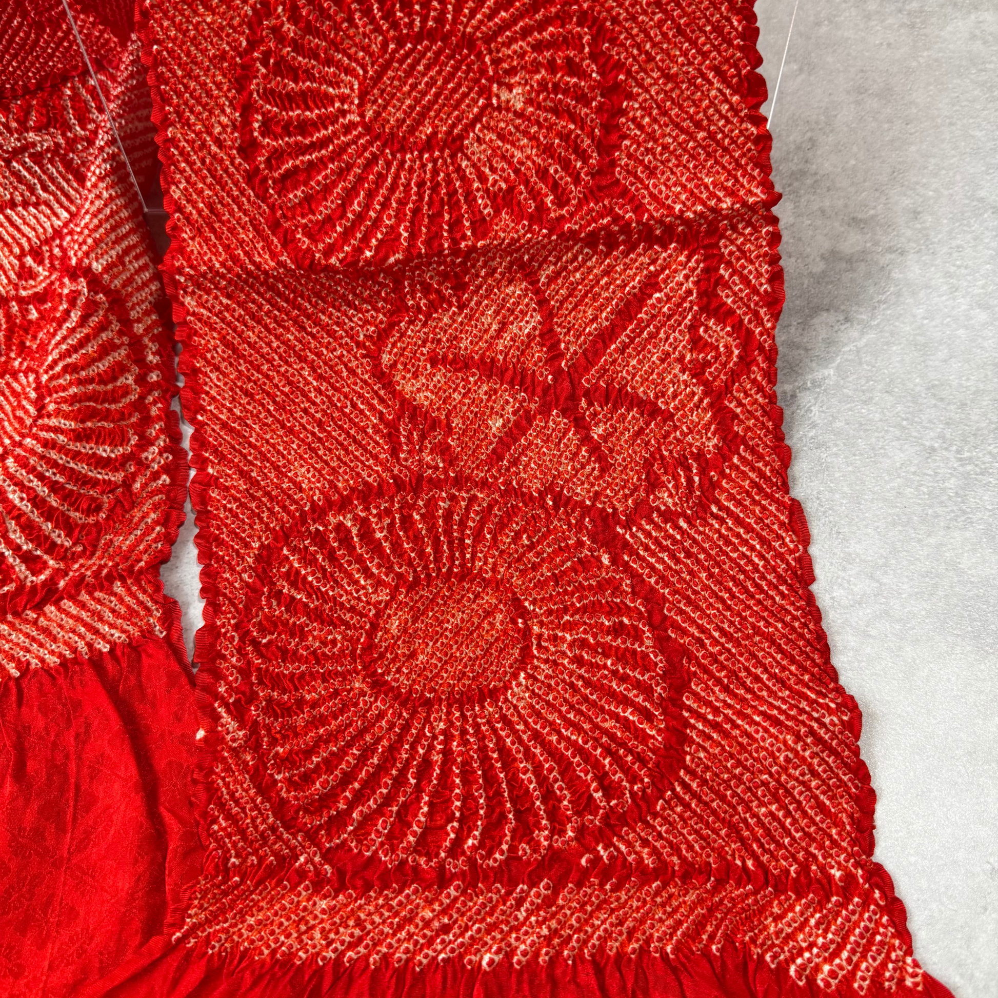 Close-up of red and white shibori floral motifs on Japanese silk obiage