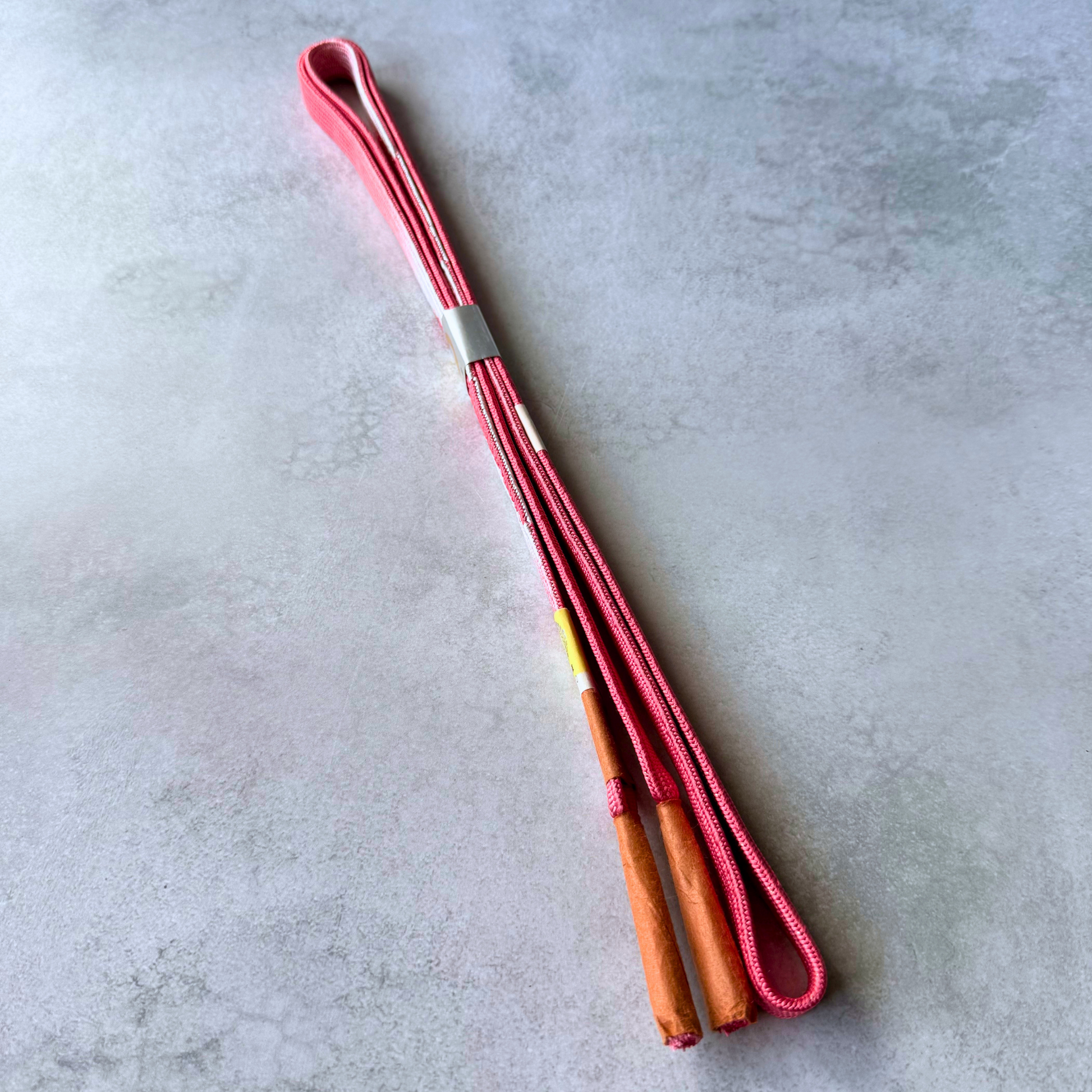 Reversible Japanese silk obijime showing both sides and wrapped tassel ends