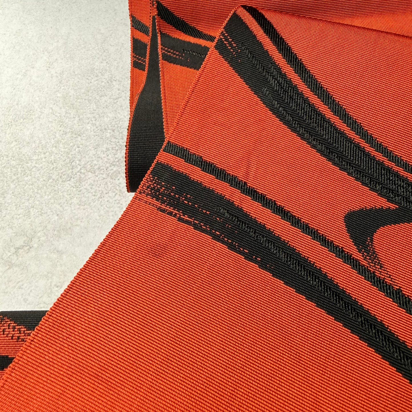Reverse and draped view of flowing water obi textile