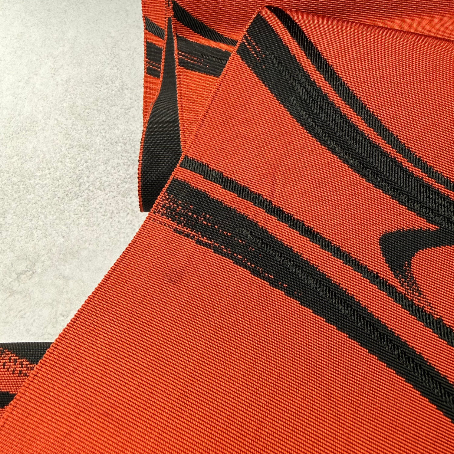 Reverse and draped view of flowing water obi textile