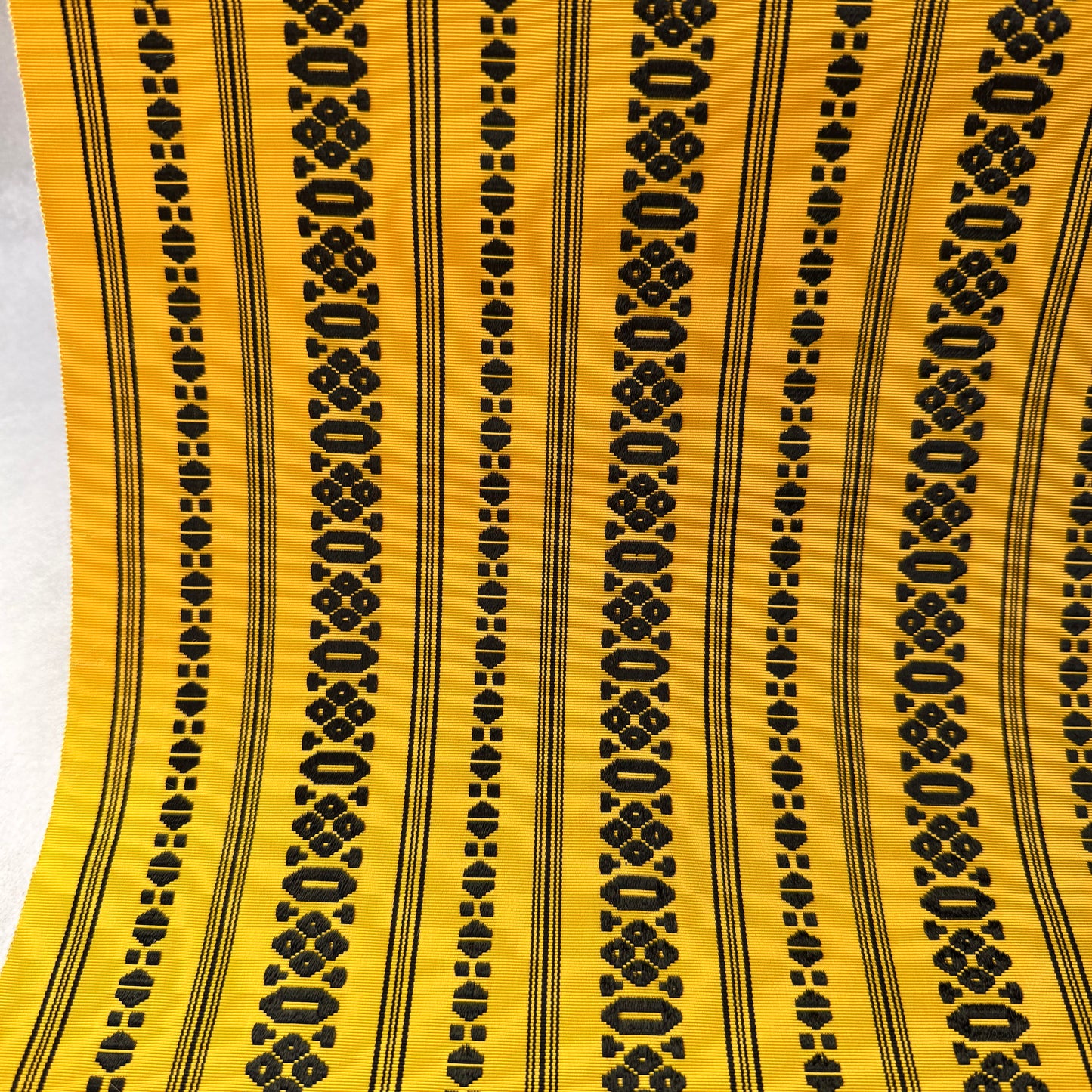 Close-up of abstract woven motifs on yellow Japanese obi fabric