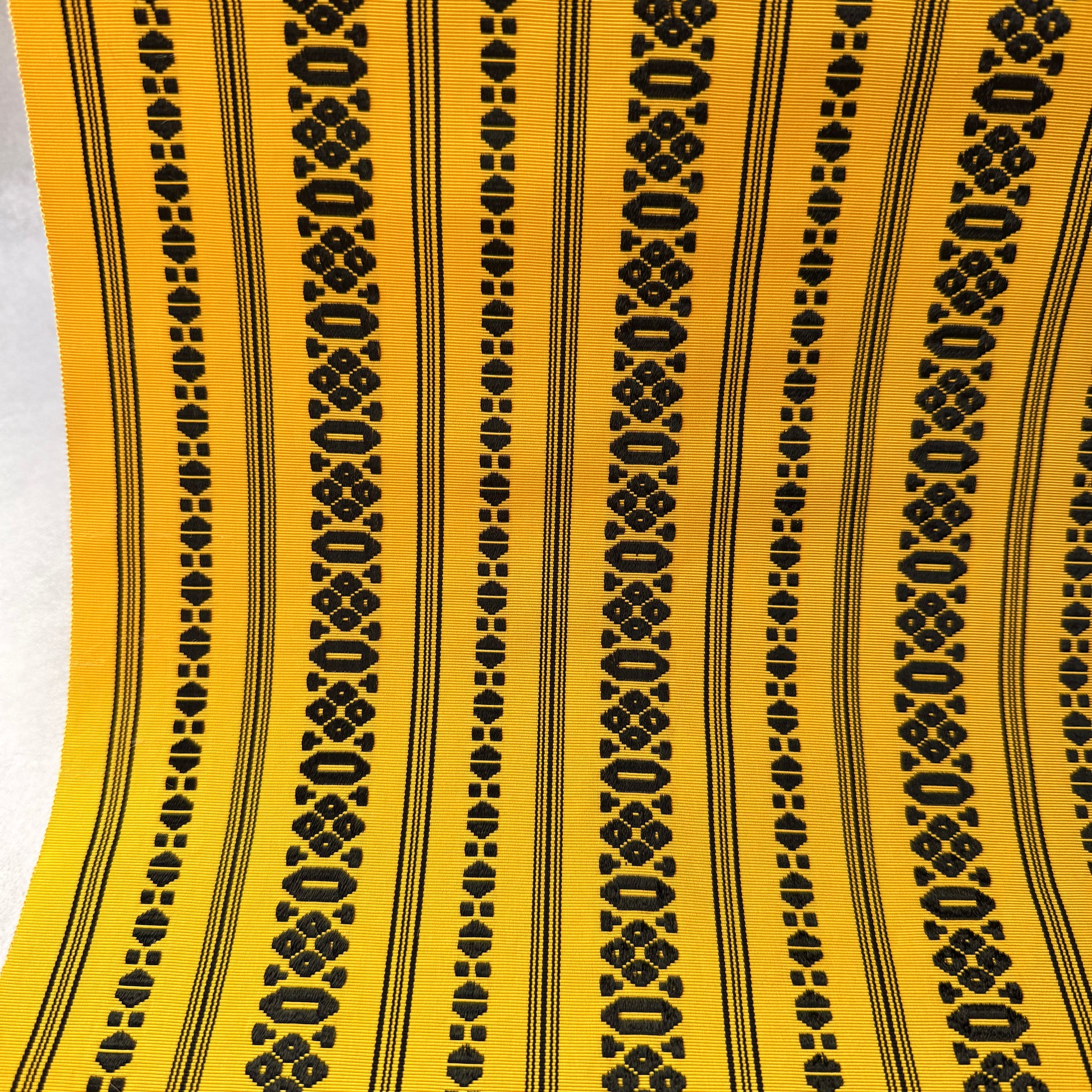 Close-up of abstract woven motifs on yellow Japanese obi fabric