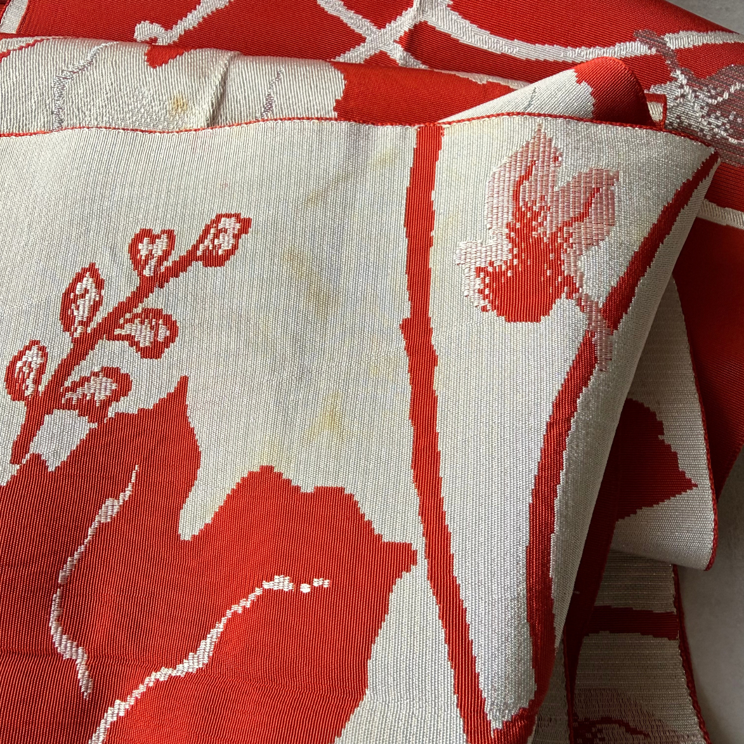 Reverse side and stained areas of reddish brown and ivory obi fabric