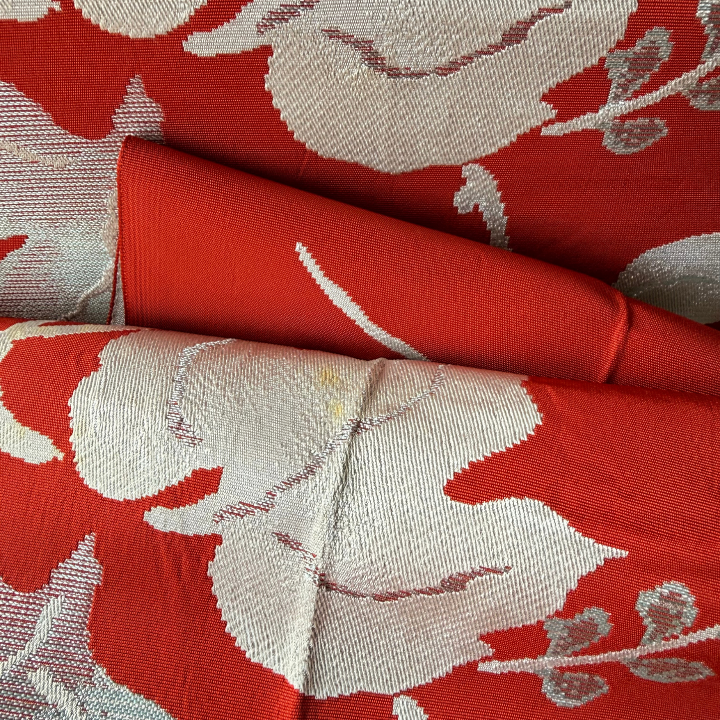 Detailed condition view of stains on woven ivy leaf obi fabric