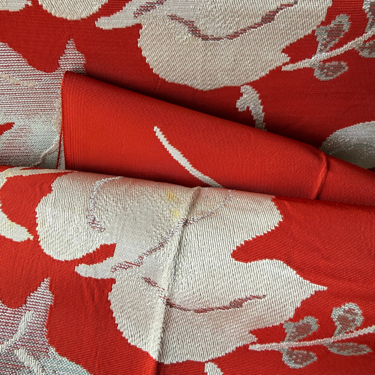 Detailed condition view of stains on woven ivy leaf obi fabric