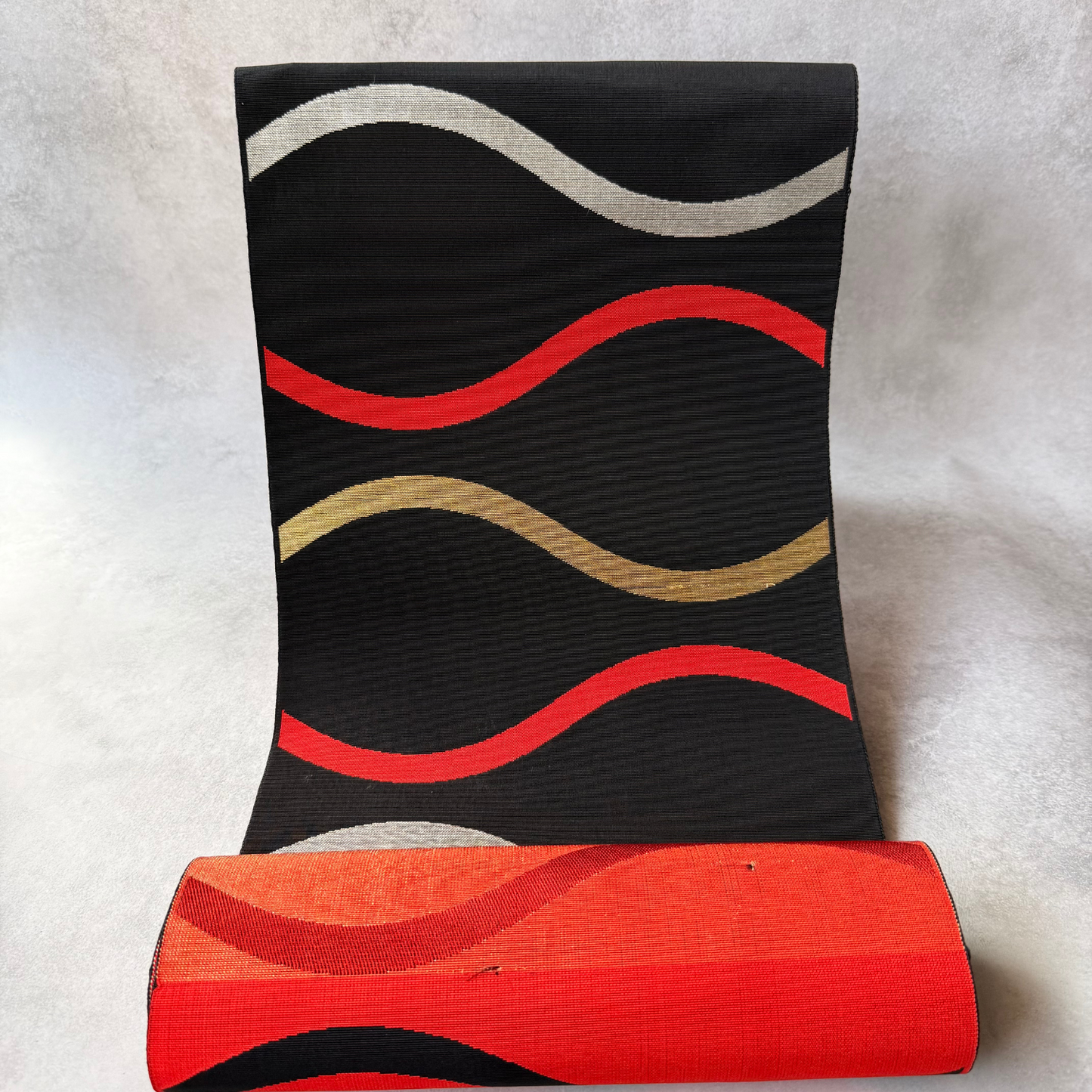 Antique black Japanese hachisun obi fabric with red gold and silver wavy bands