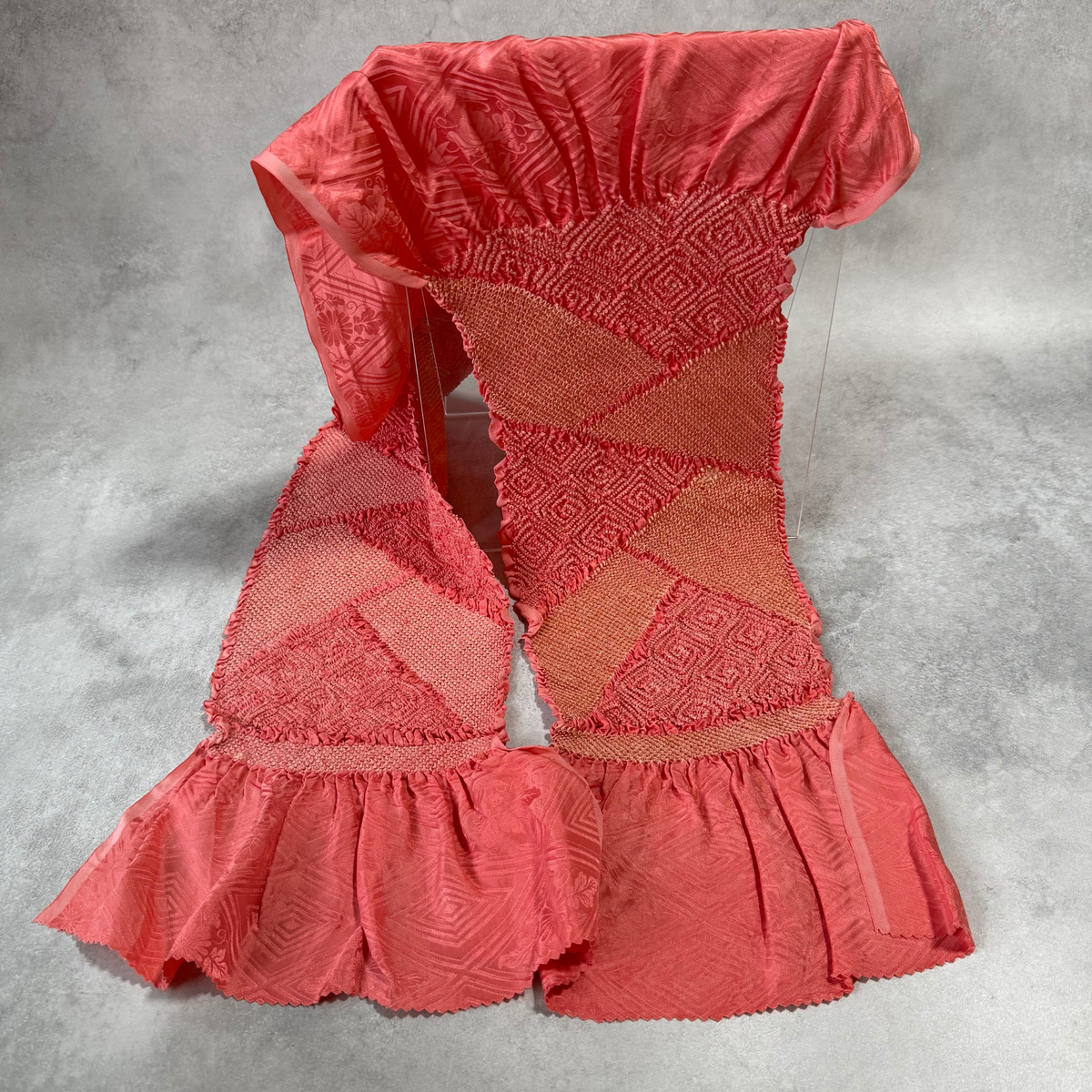 Full view of vintage Japanese coral pink silk shibori obiage with geometric diamond panels