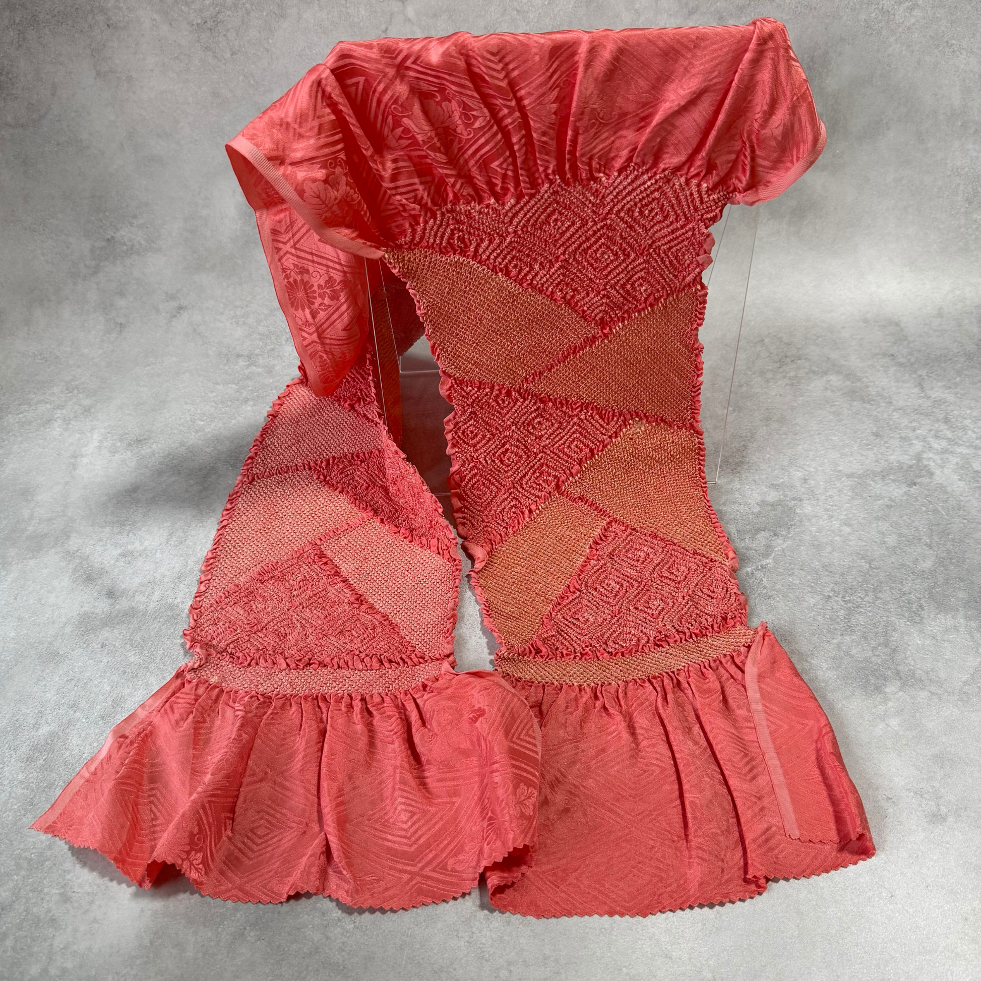 Full view of vintage Japanese coral pink silk shibori obiage with geometric diamond panels