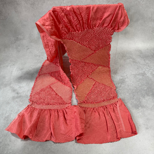 Full view of vintage Japanese coral pink silk shibori obiage with geometric diamond panels