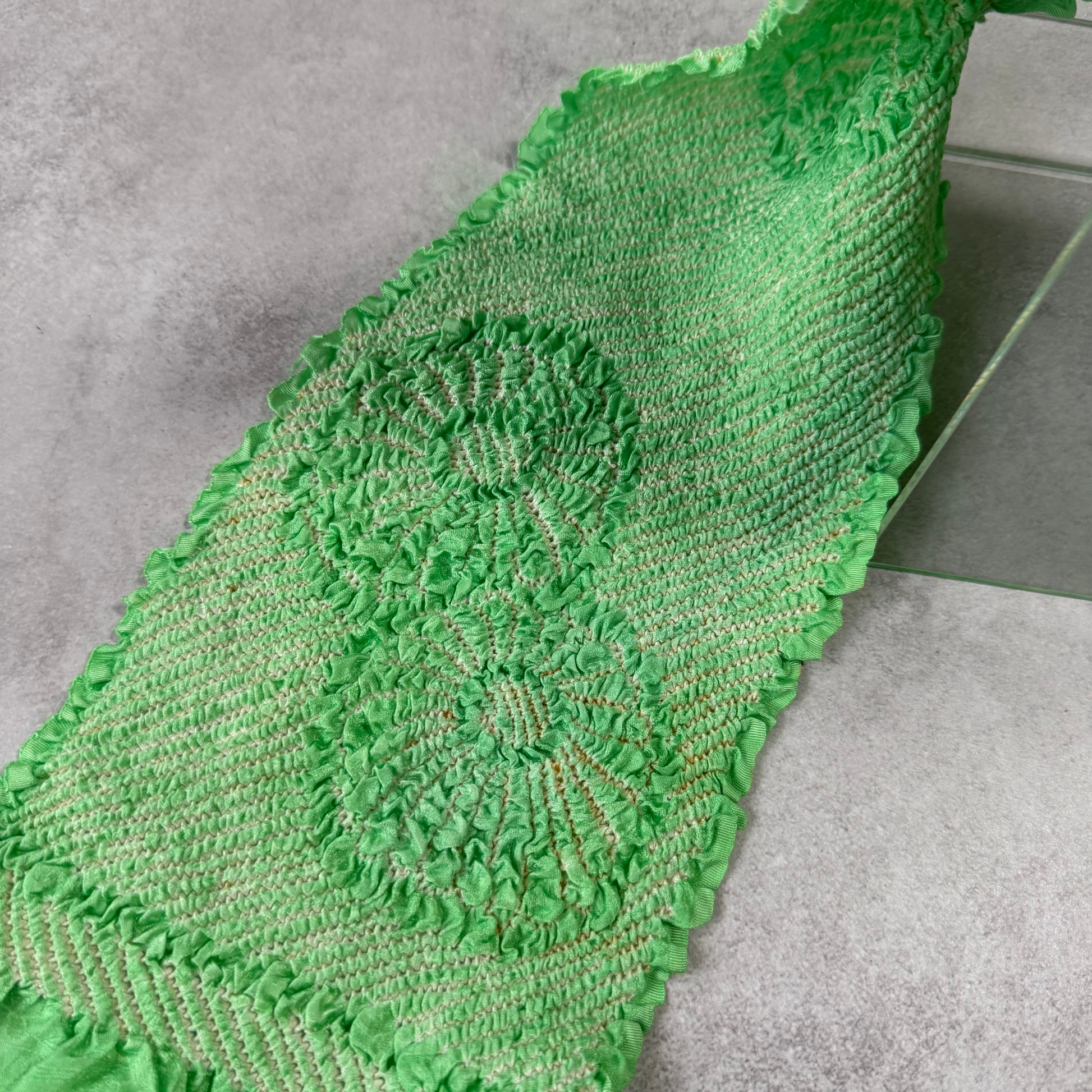 Close-up showing a large floral shibori design and condition details on green silk
