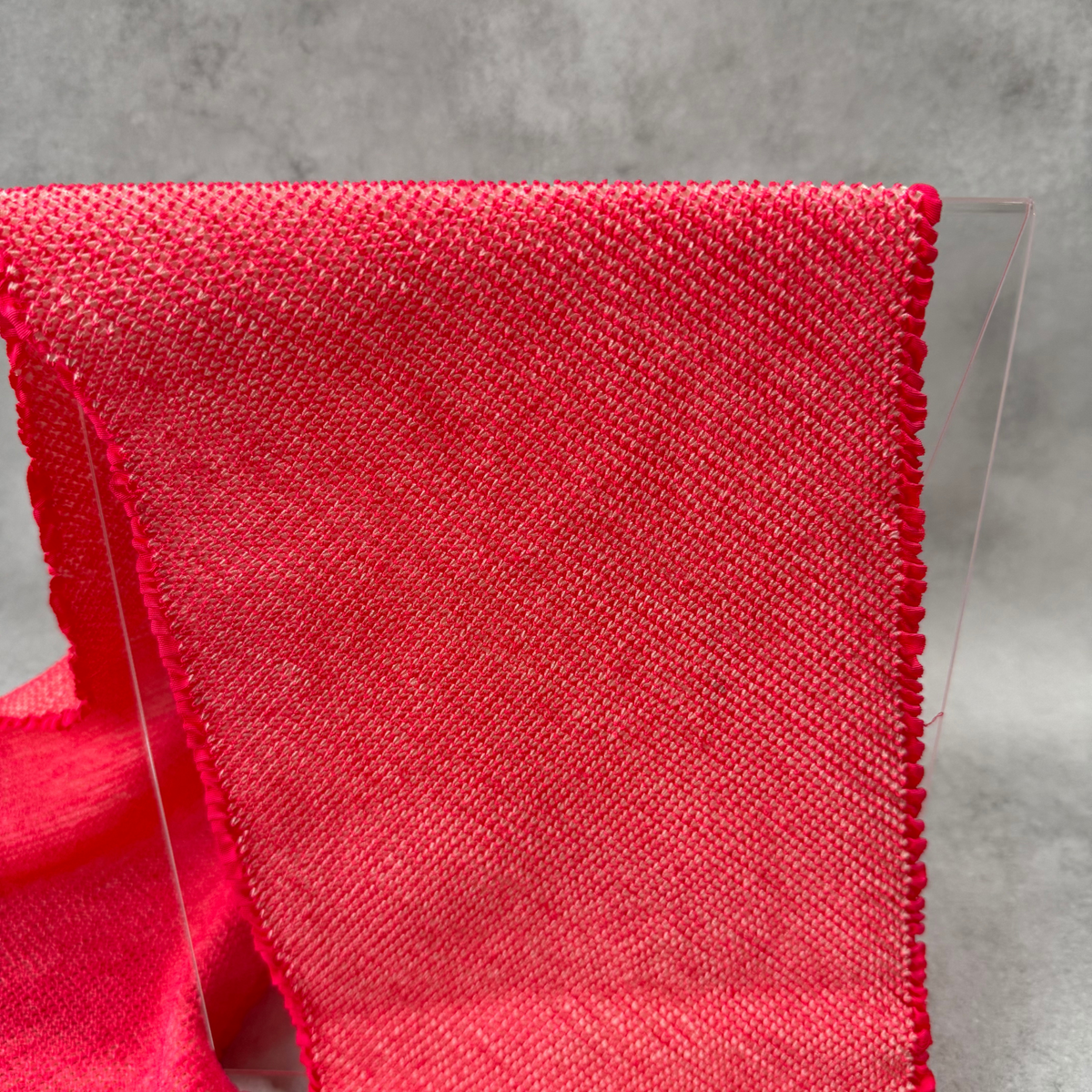Macro view of fine all-over shibori dots on a vivid pink Japanese silk obiage